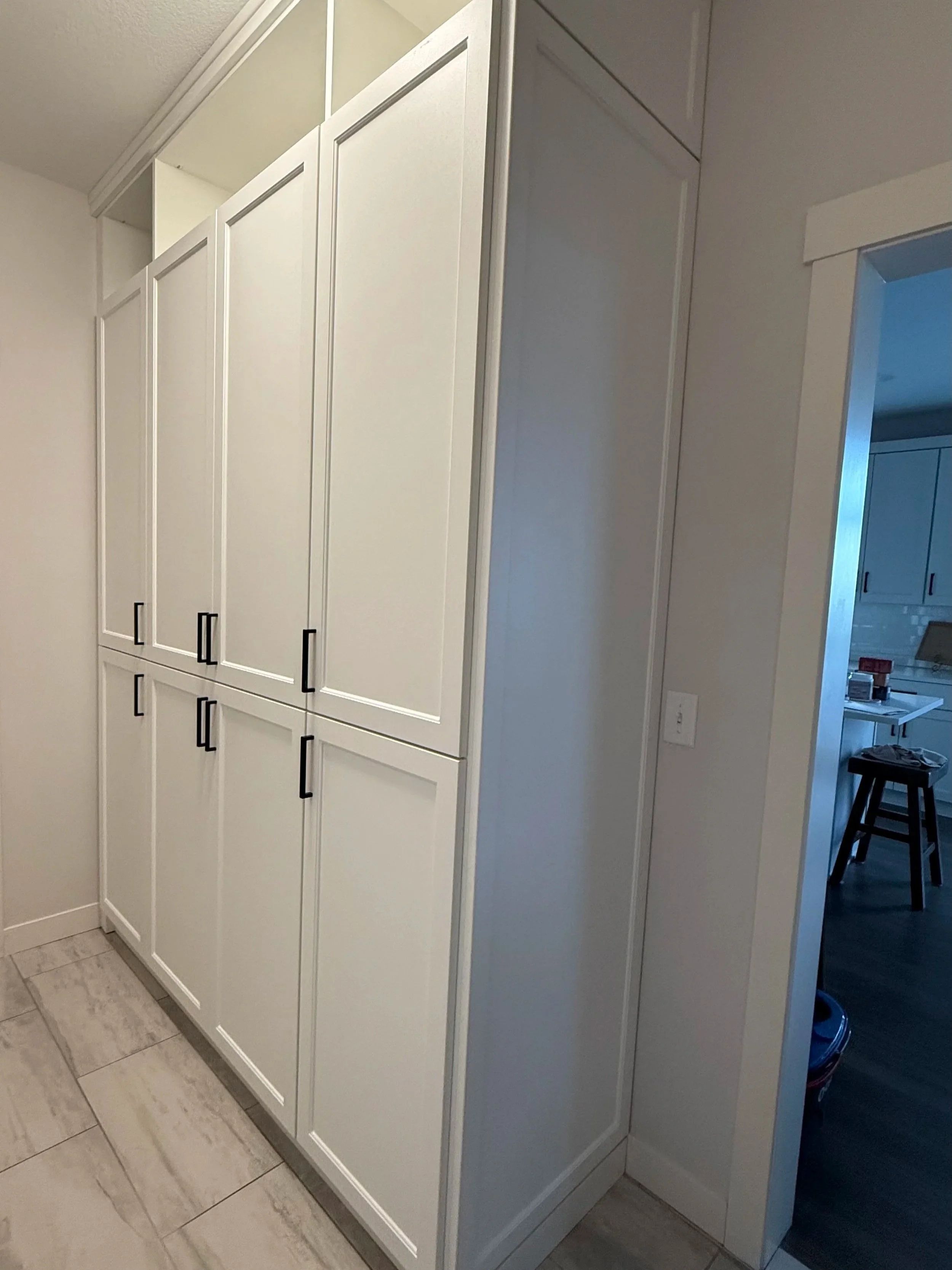 Custom white storage cabinets installed as part of a home organization project