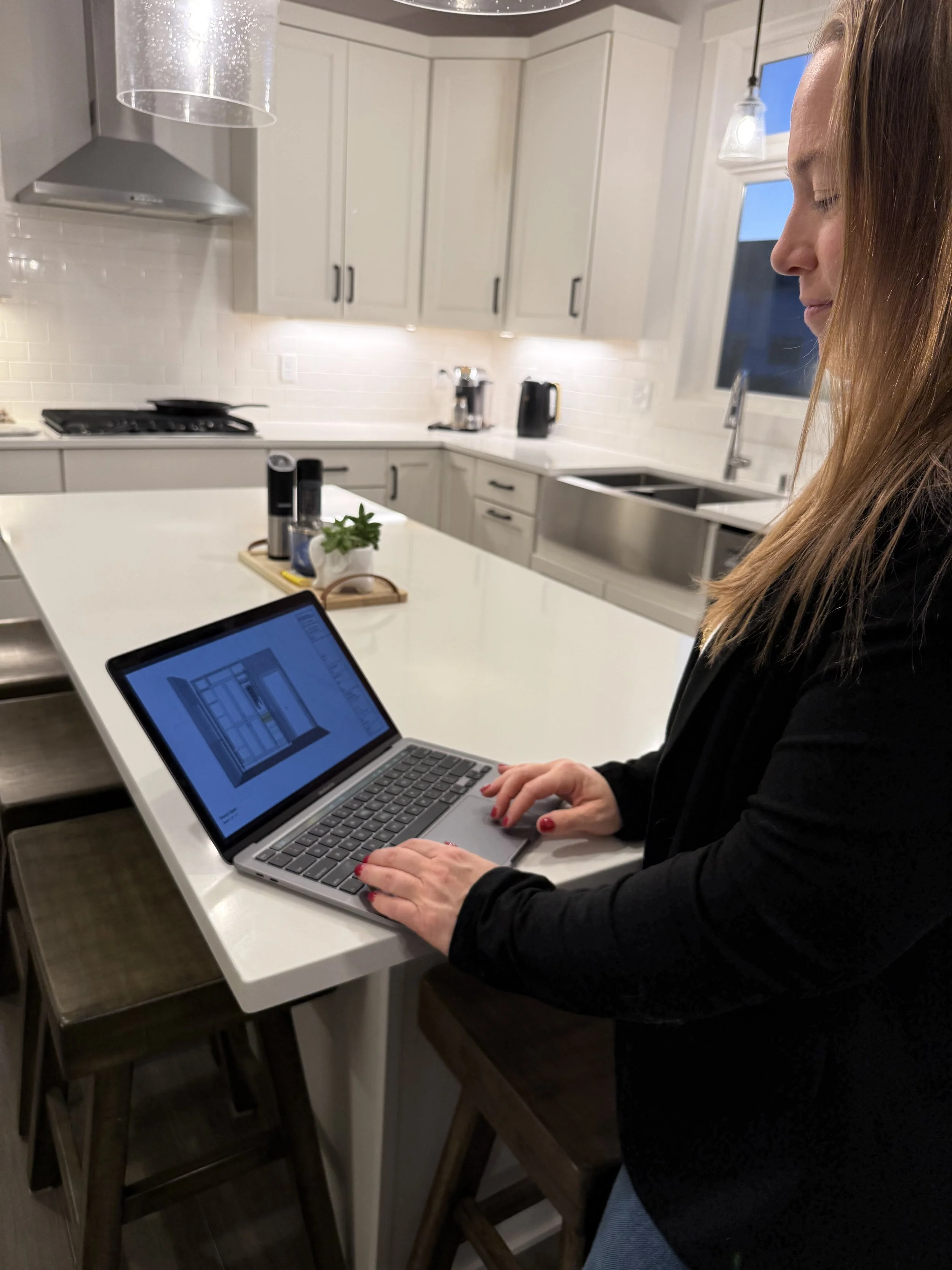 Ashley planning a custom organization and closet design on a laptop in a kitchen