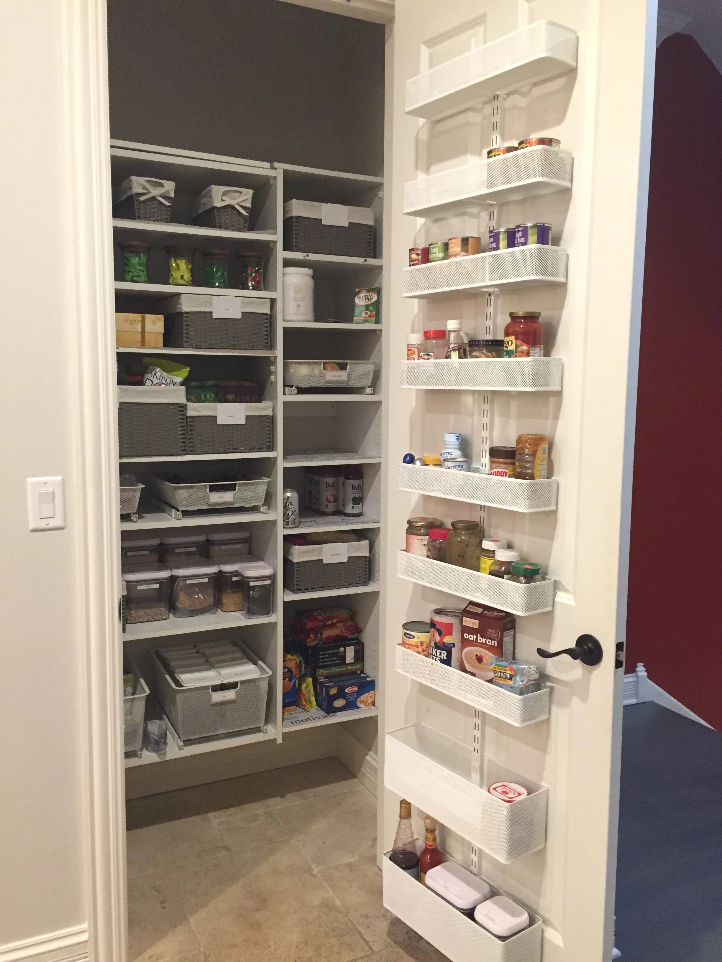 Pantry with organized shelves containing food containers, canned goods, spices, and condiments.