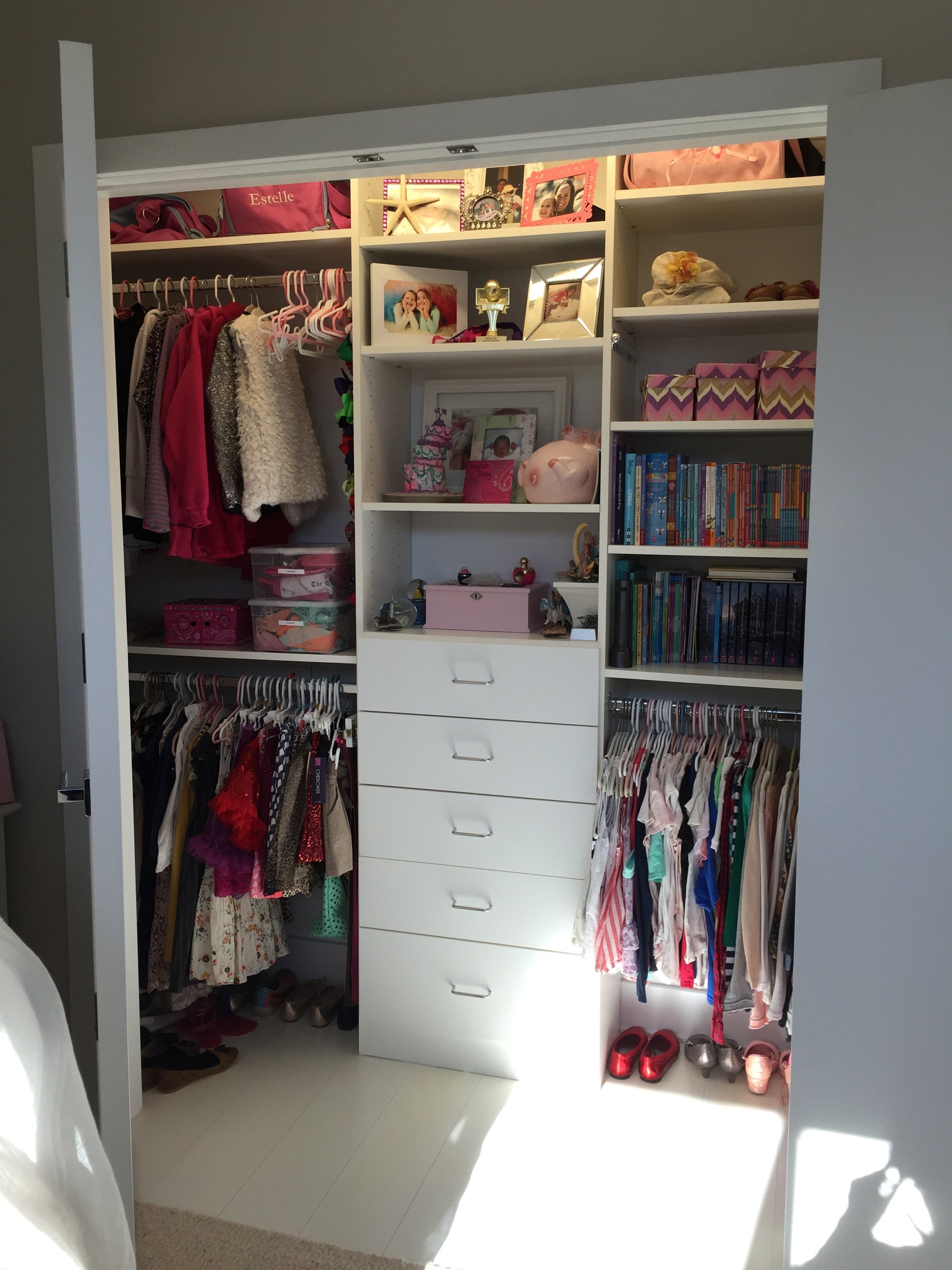 A closet with clothing, shoes, and decorative items.