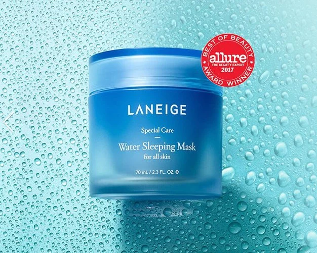 Blue jar of skincare mask product sits on a blue reflective surface covered by water droplets