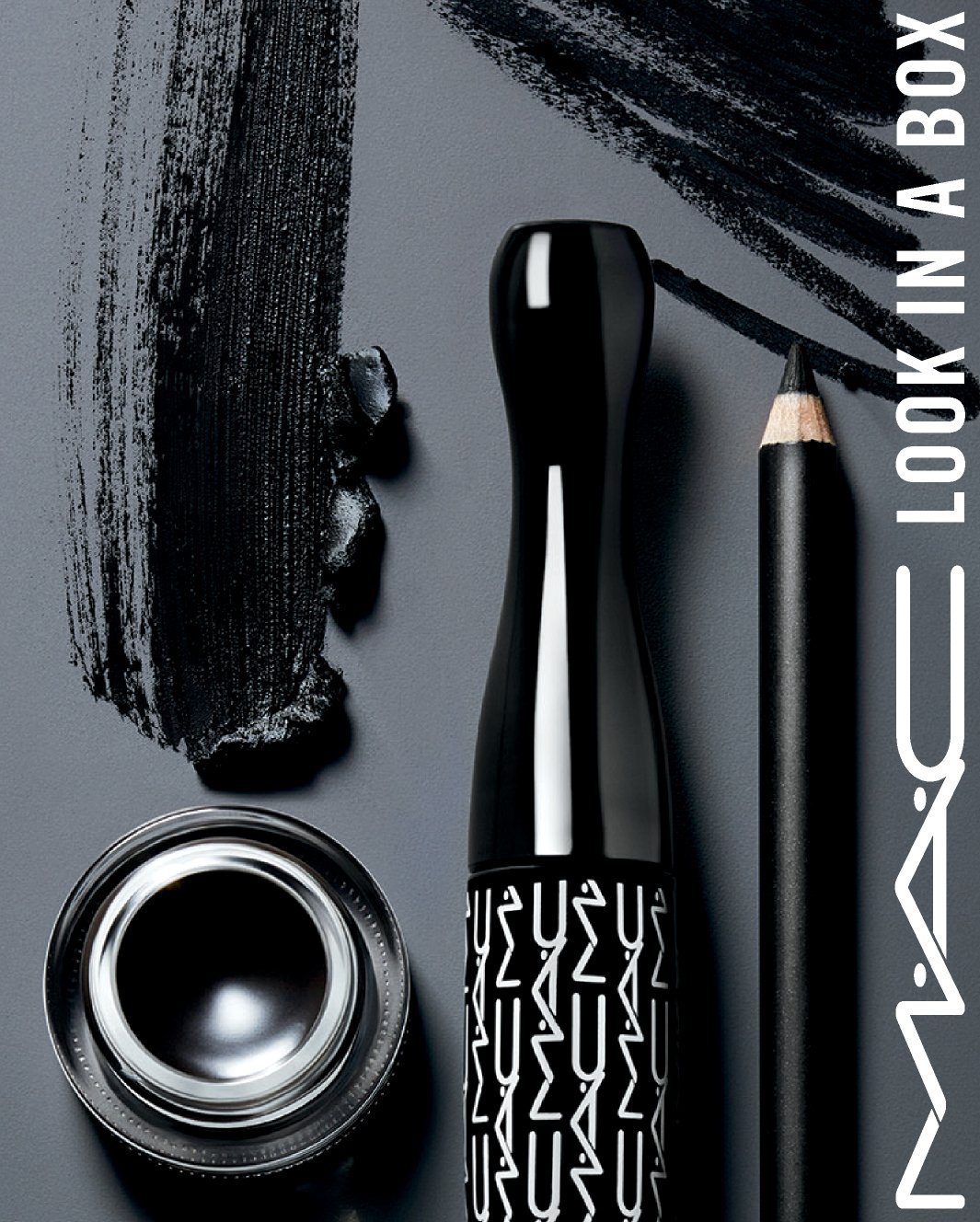MAC Cosmetics eyeliner, mascara, and eyshadow products and texture color swatches are shown against a deep gray backgrapund with crisp shadows