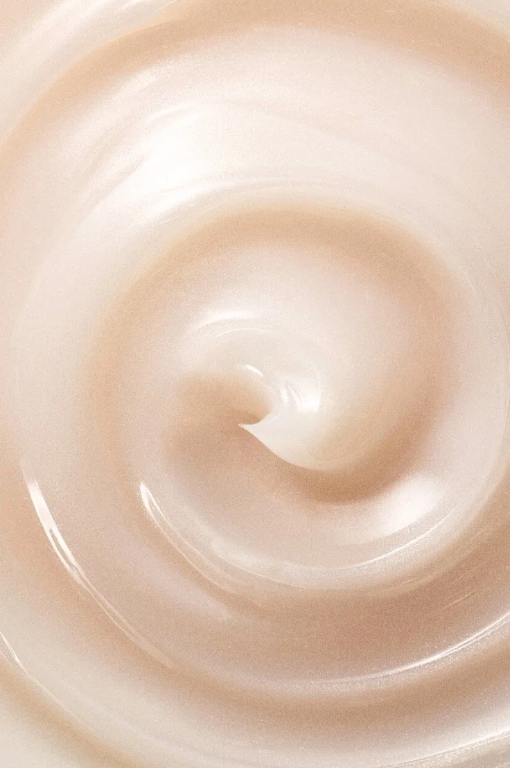 Pink hued gel face cleanser with circular swirls in a top-down macro view