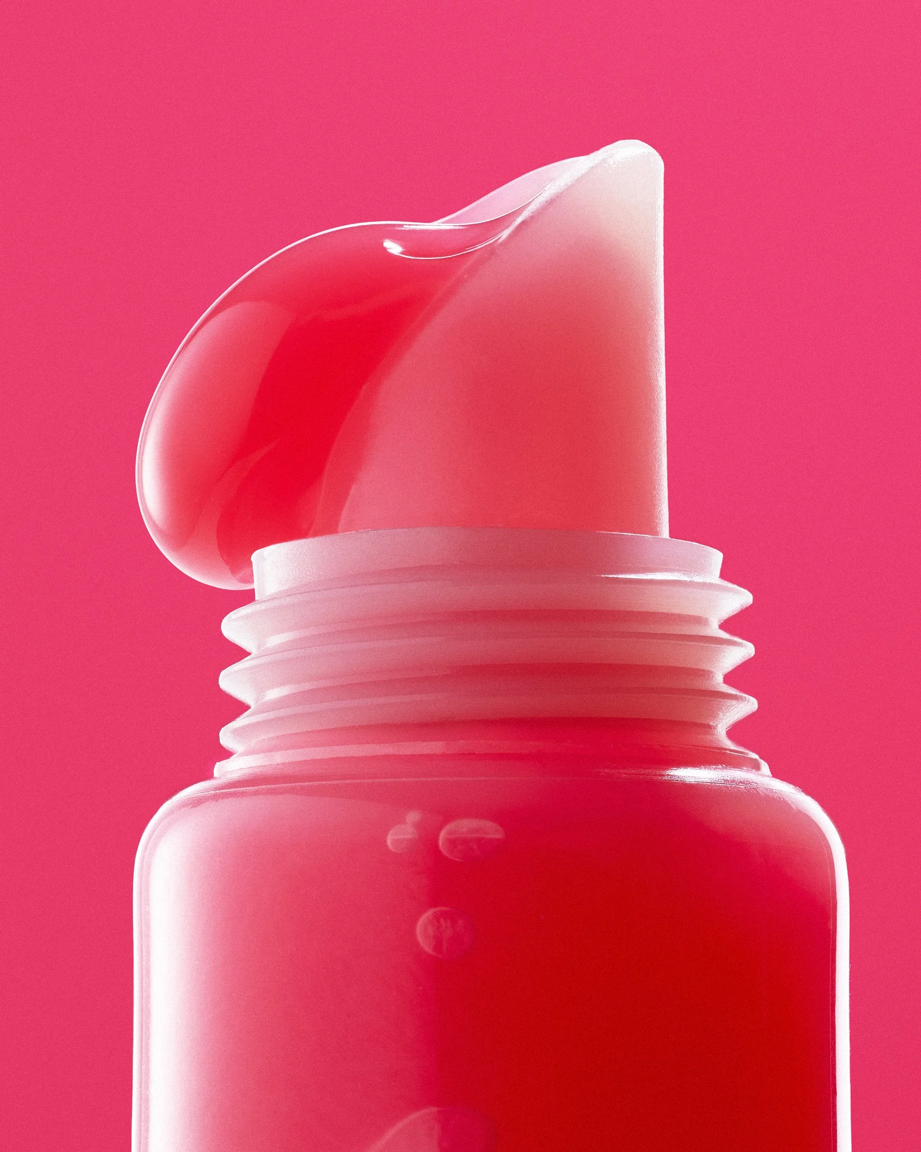 Lip Gloss Macro texture blob on monochromatic hot pink background