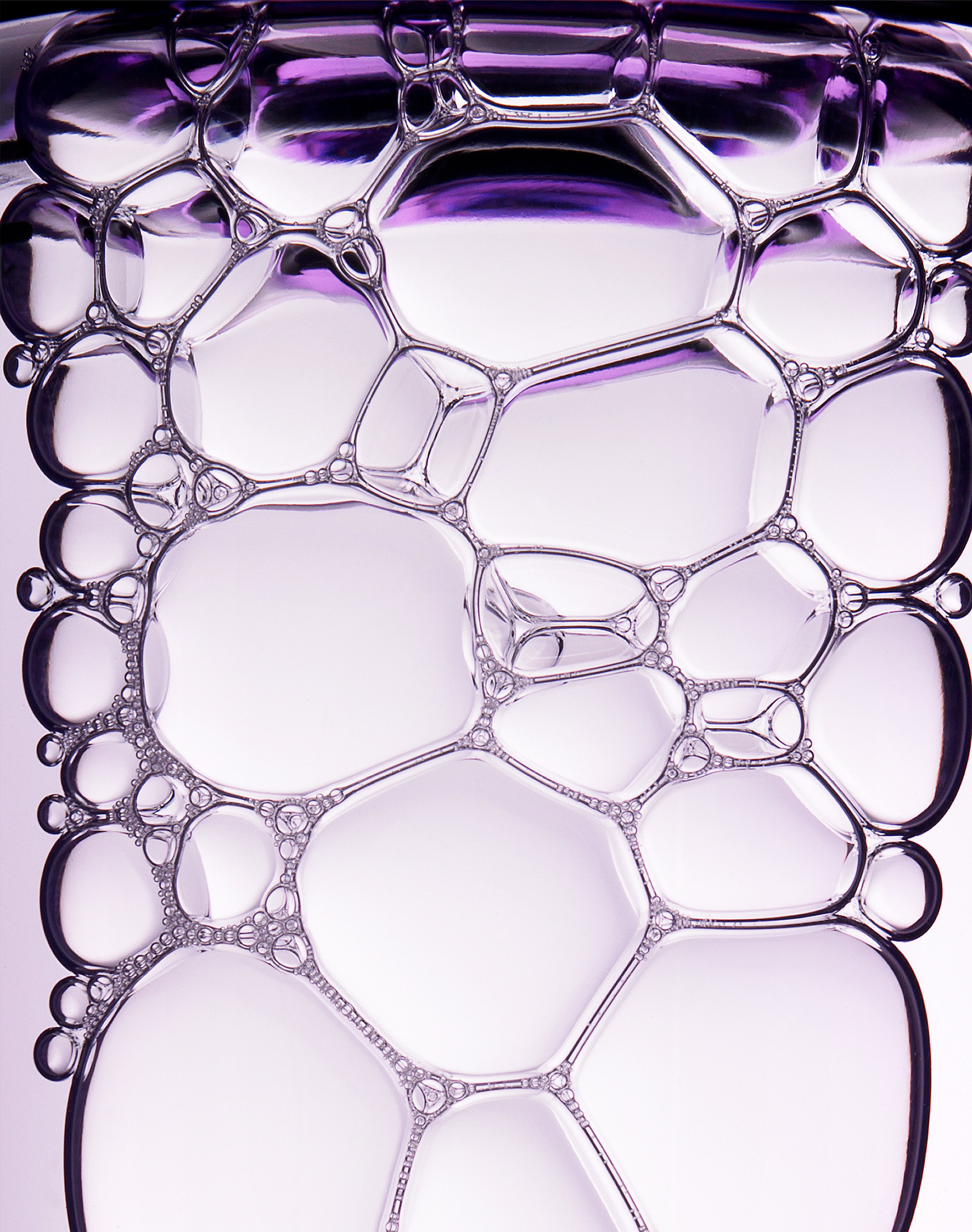Macro closeup showing light purple bubbles inside a bottle of makeup remover