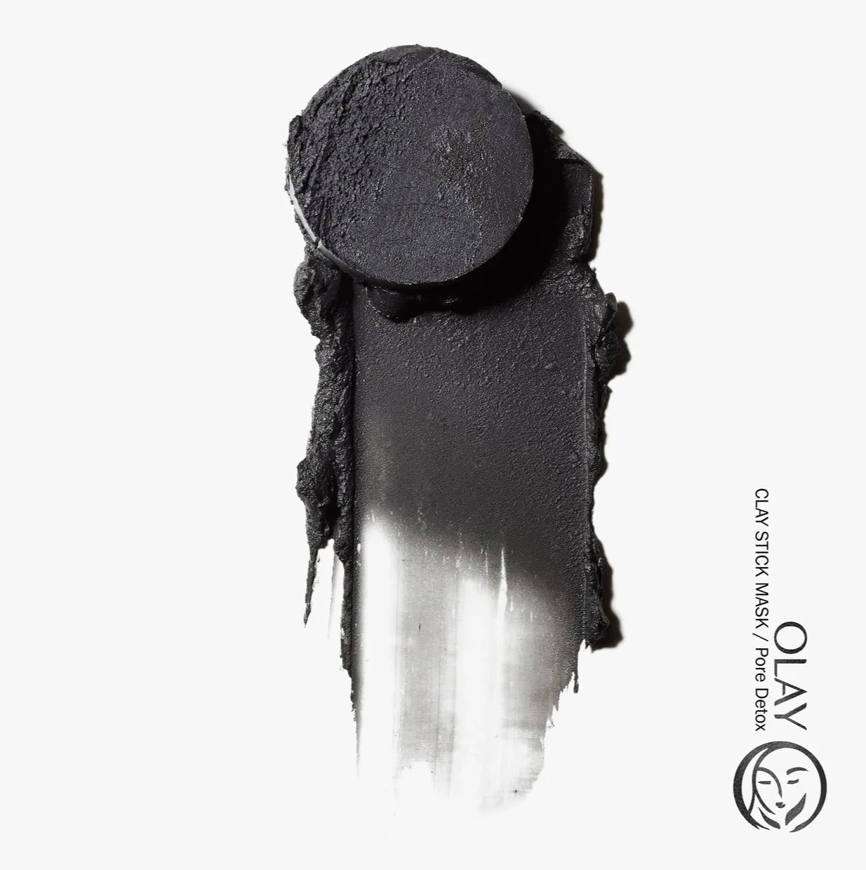 A stylized swoosh and slice of black paste is shown on a white background with a crisp shadow to represent the texture of Olay ClayStick Mask