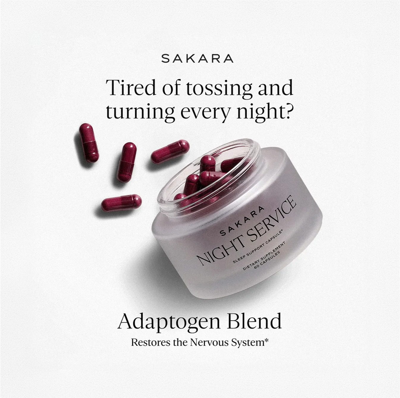 A clear frosted open jar of burgundy vitamin supplment leans as capsules spill onto a white background