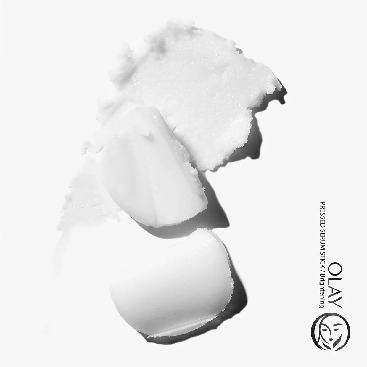 A stylized swoosh and stack of white paste is shown on a white background with a crisp shadow to represent the texture of Olay Serum Stick