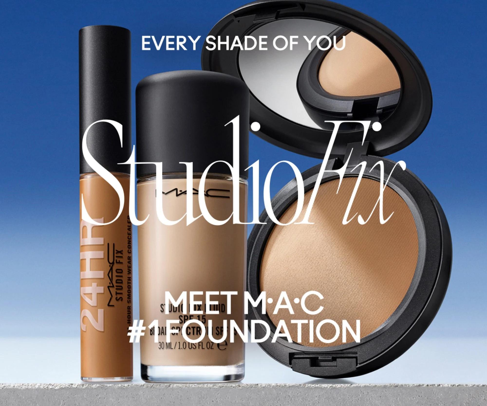 Three foundation makeup products in black packaging stand on a cement ledge with a blue gradient sky-like background