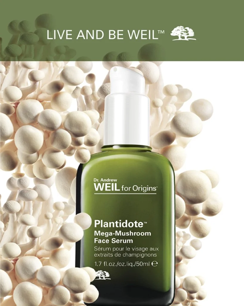 A green glass skincare serum product with white pump is shown nestled into white button mushrooms on a backlit white background