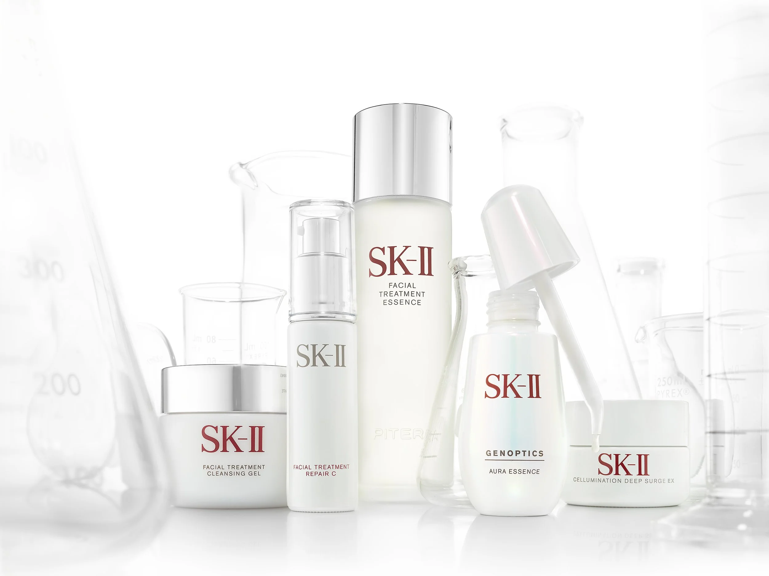SK-II Aura Genoptics products shown in a crisp white setting featuring labratory glass beakers