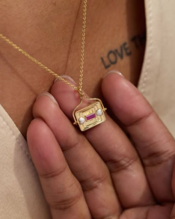 close up of gold pendant necklace on model