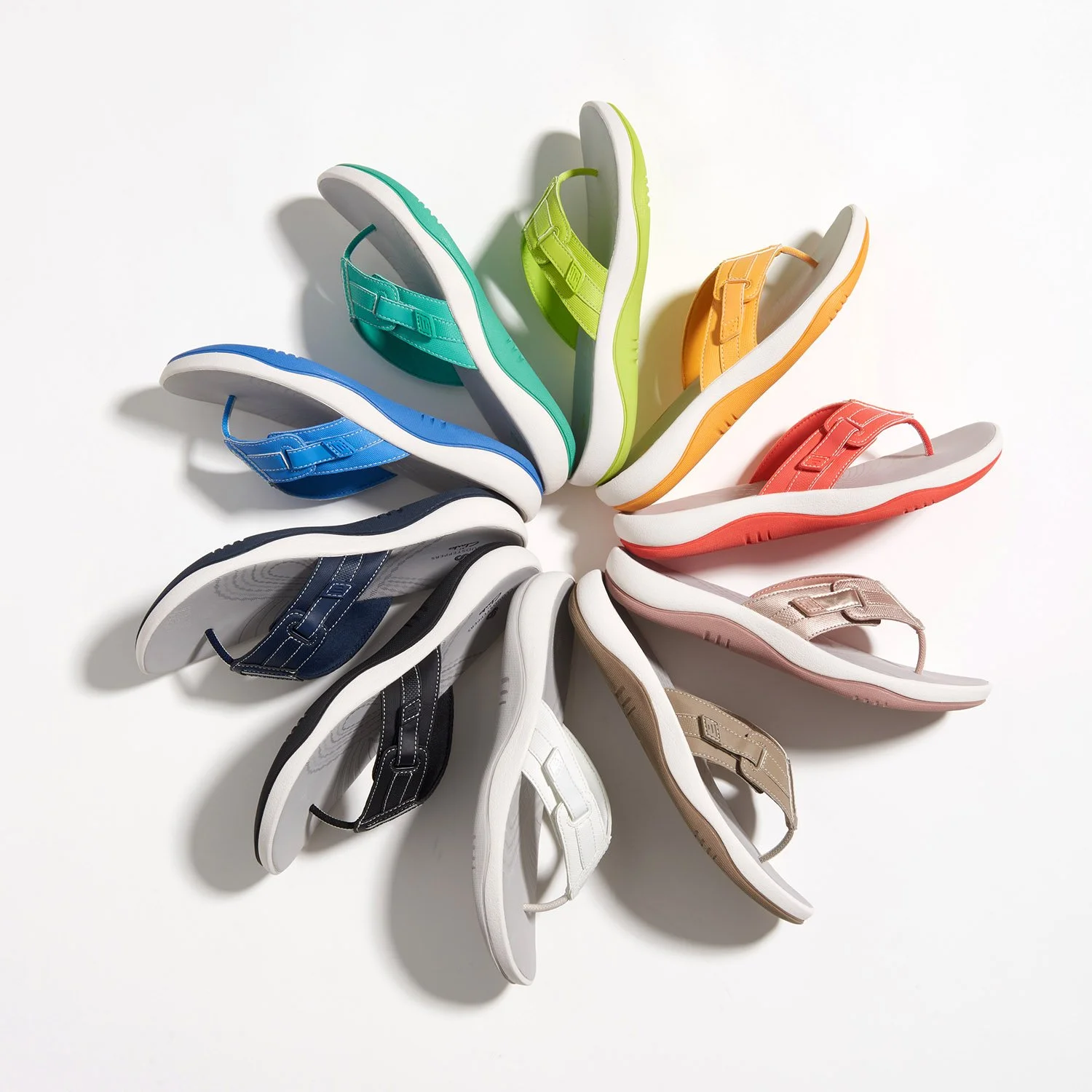 colorful sunlit flip-flops arranged in a circle pattern viewed from above
