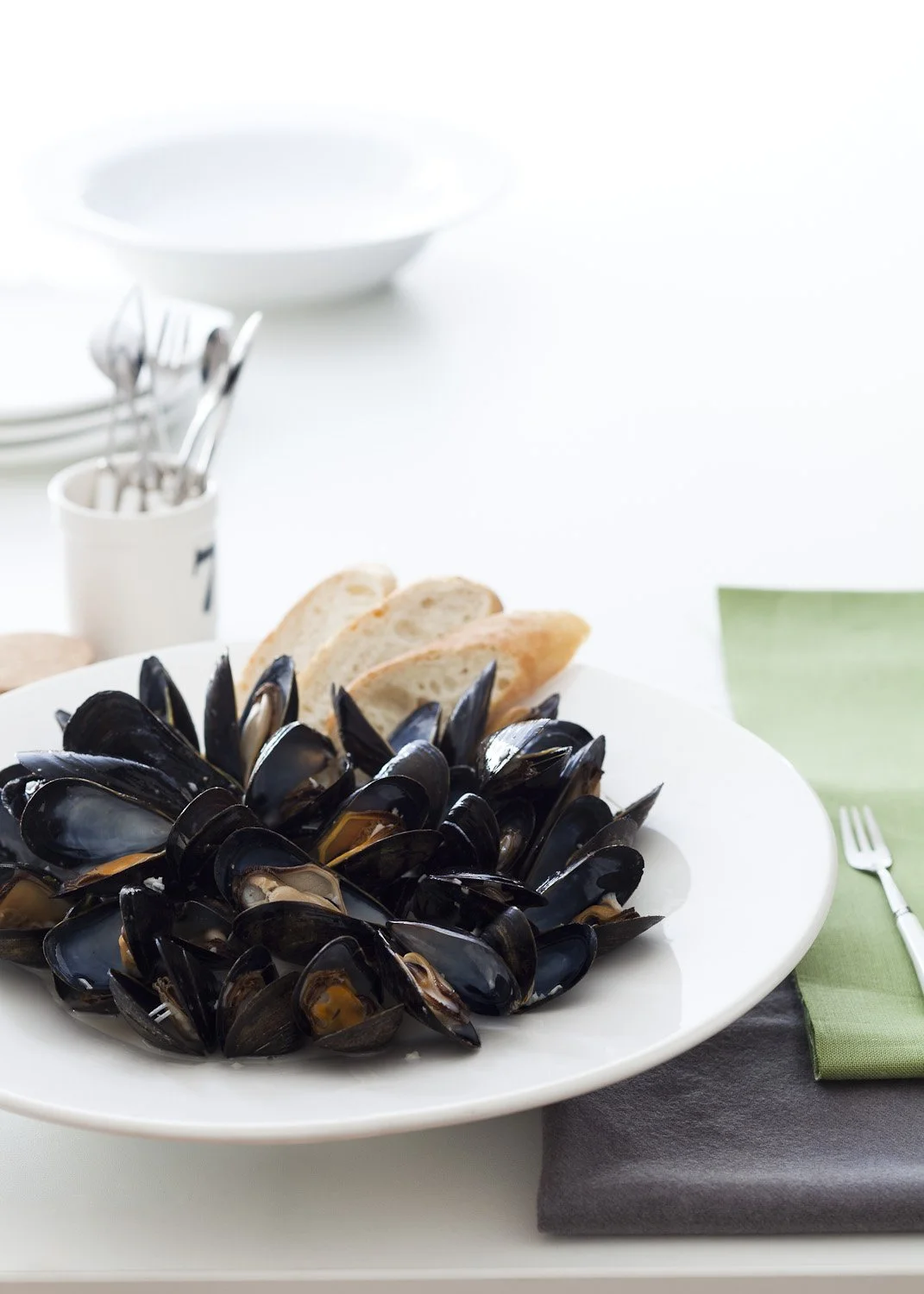 plate of mussels on white background with green and grey napkins