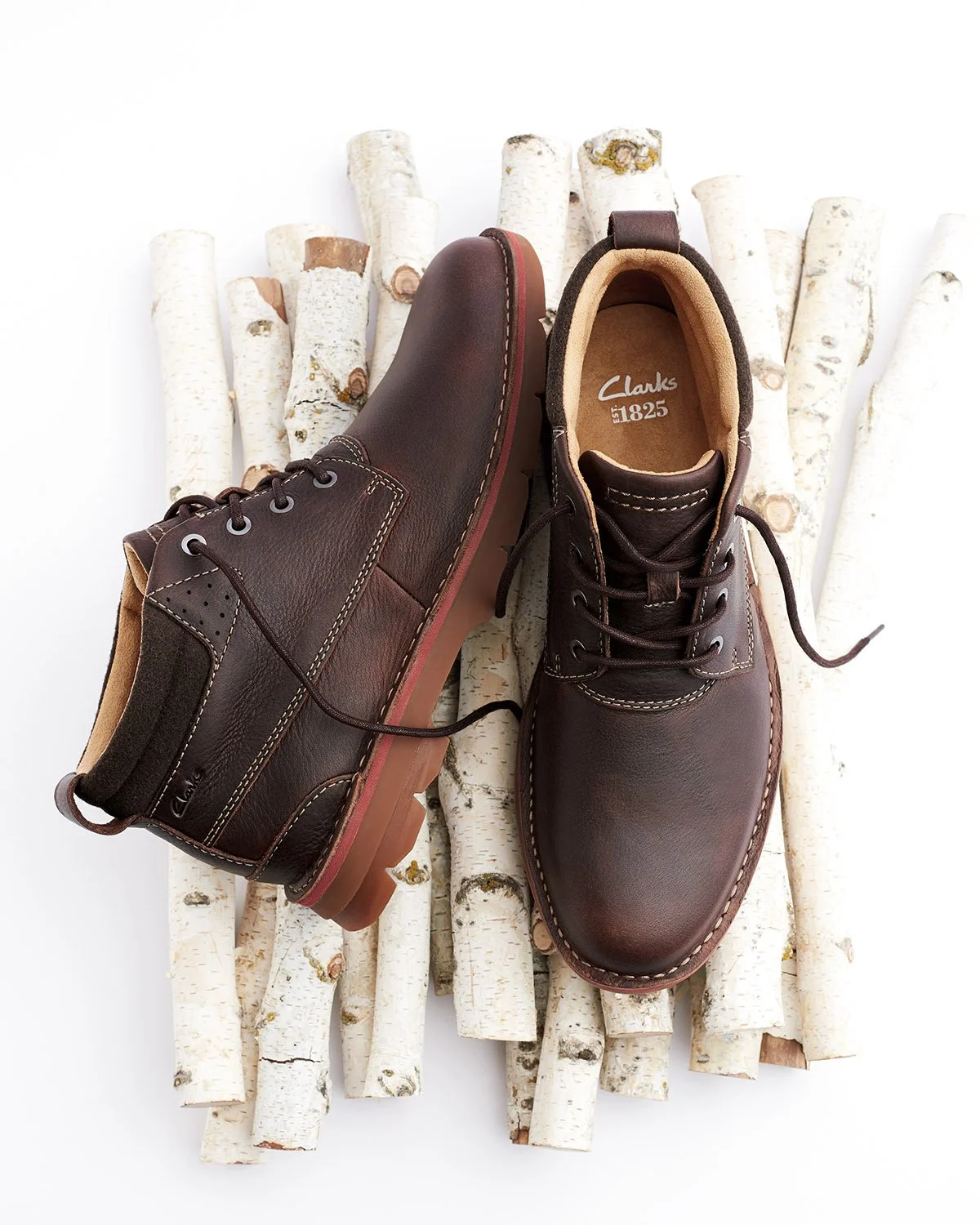 mens lace-up brown boots on birch log pile