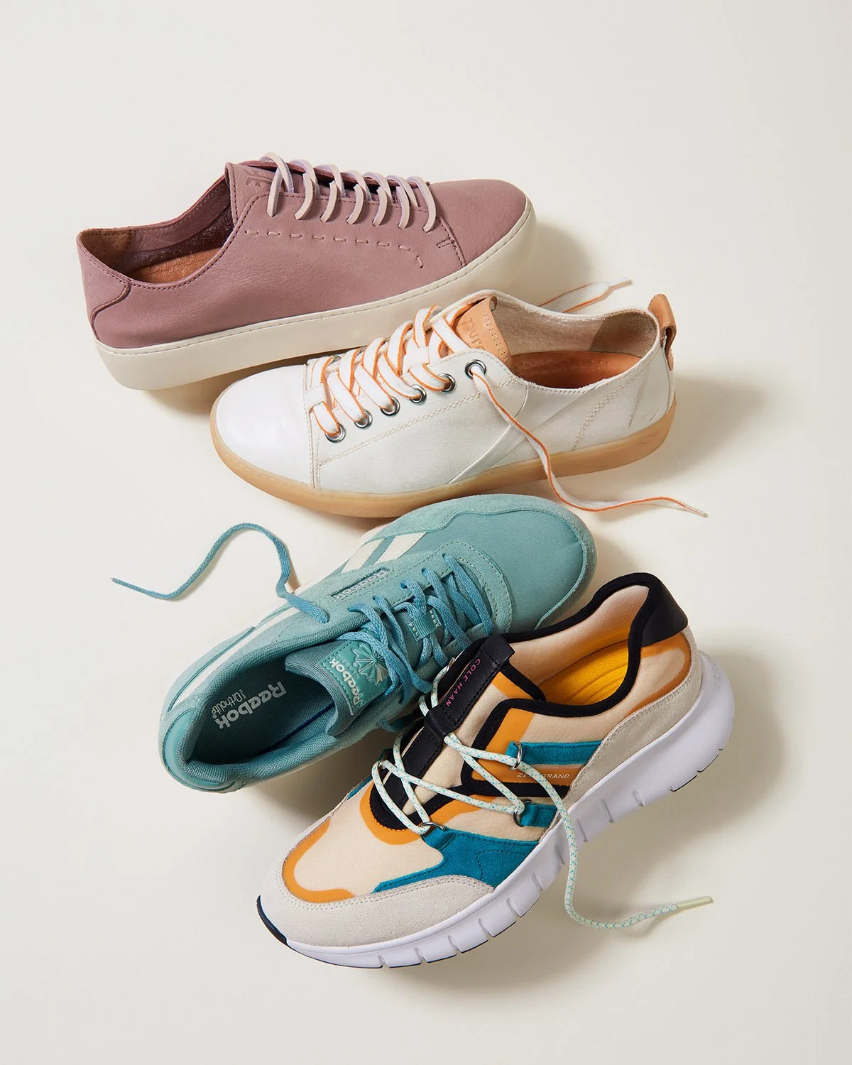 tumble of casual women's lace up shoes on cream background