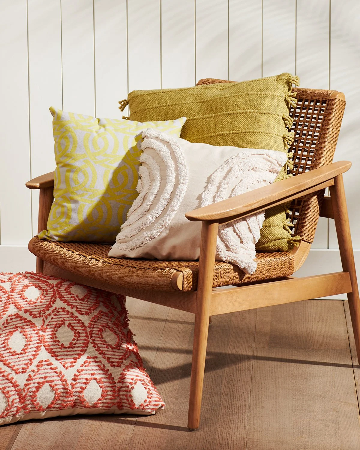 pillows arranged on wood and woven seat chair