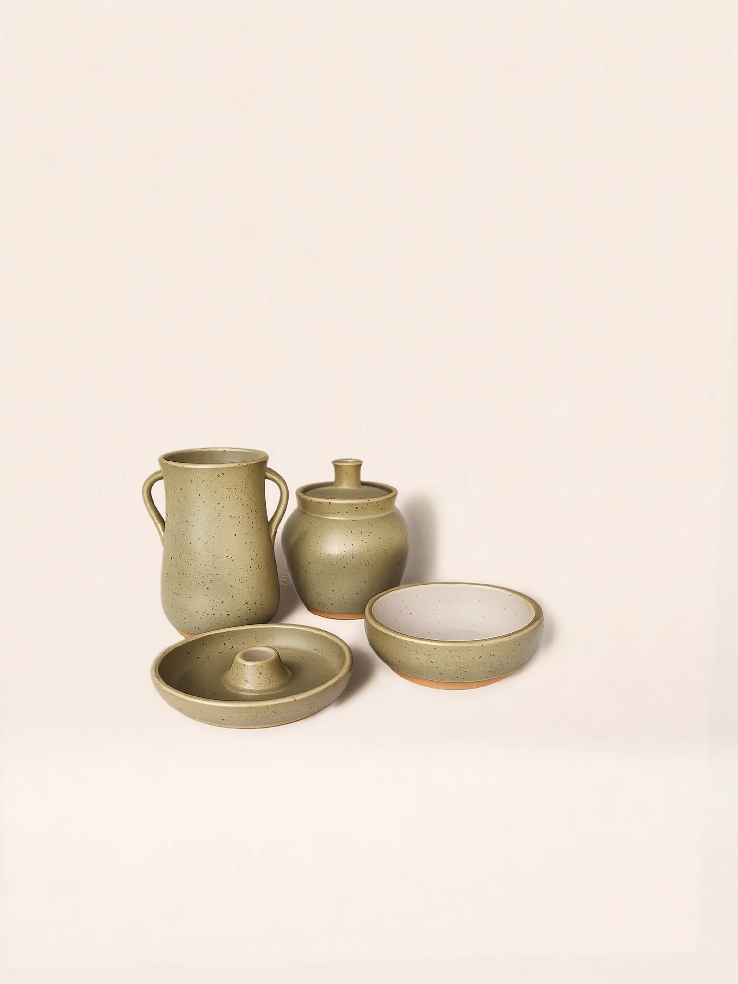 Set of five beige ceramic pottery pieces on a white background, including a vase with handles, a jar with a lid, a bowl with a smaller ring inside, a shallow dish, and a round plate.