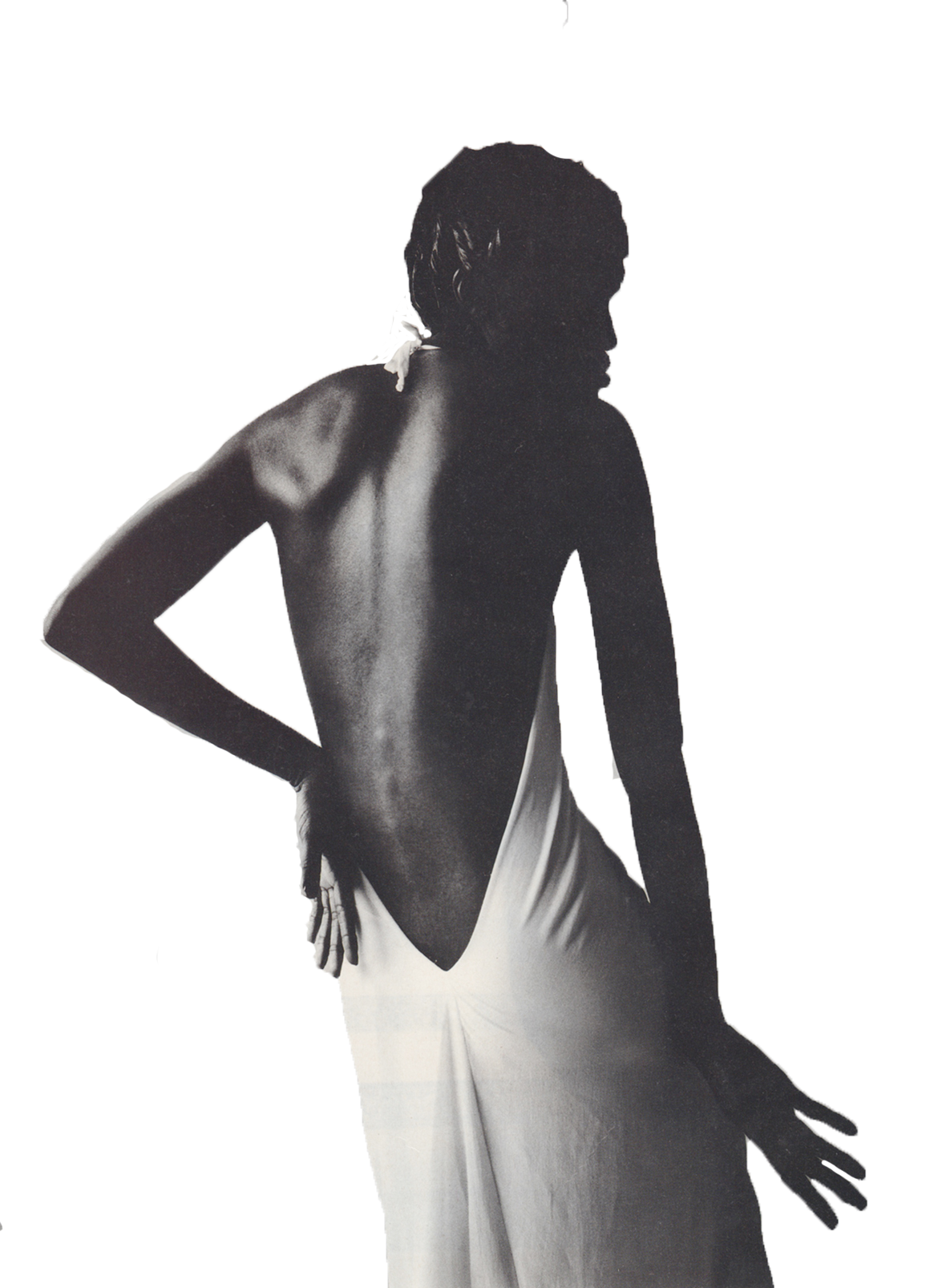 Black and white image of a woman with her back turned, wearing a skirt and topless, with one hand resting on her hip and the other extended outward.