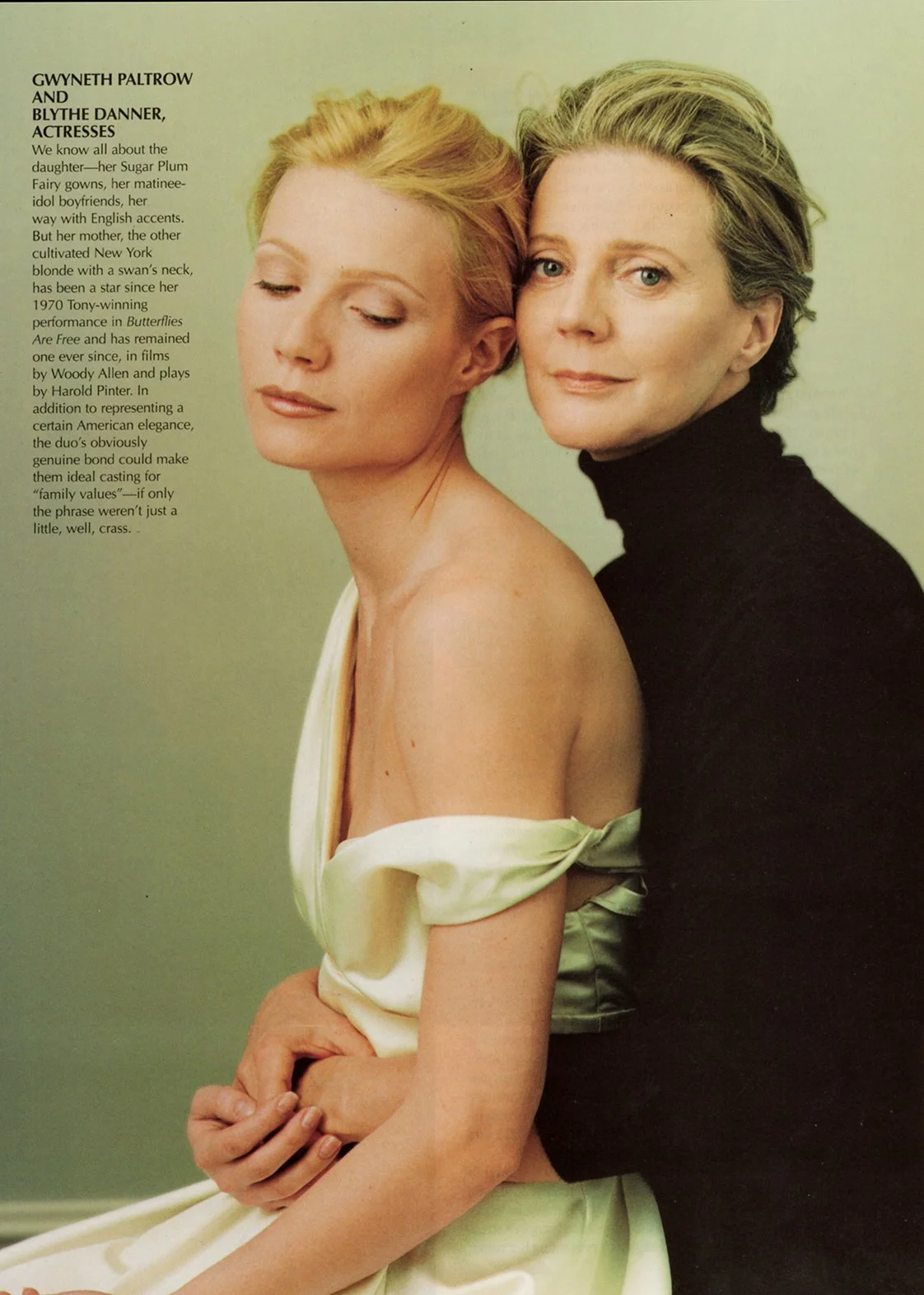 Photograph of actresses Gwyneth Paltrow and Blythe Danner, with Gwyneth wearing a cream-colored off-shoulder dress, and Blythe wearing a black turtleneck, both posing closely with Gwyneth tilting her head downward with eyes closed and Blythe looking at the camera with a slight smile.