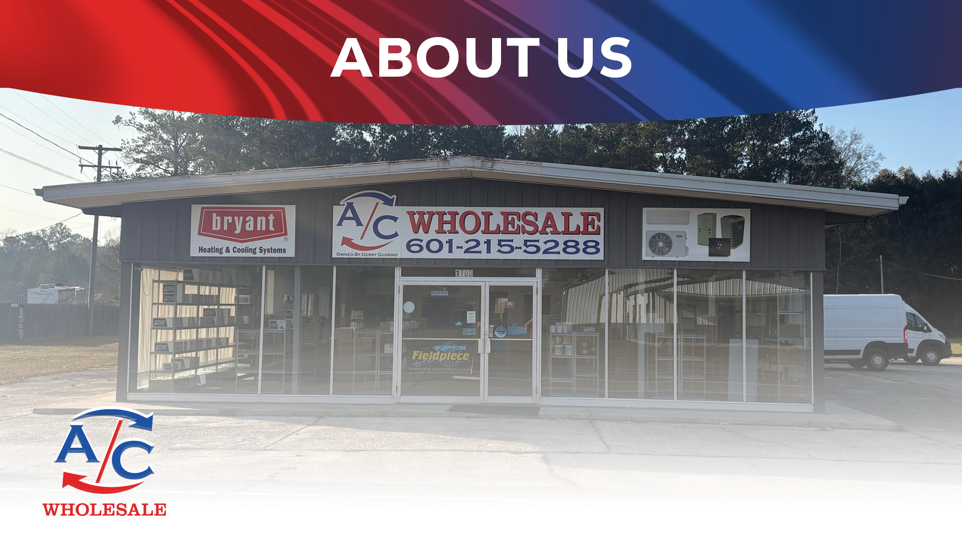 A storefront with signs for A/C Wholesale and Bryant Heating & Cooling Systems, with glass windows and a glass door, a white van parked to the right side, and a background of trees and power lines.