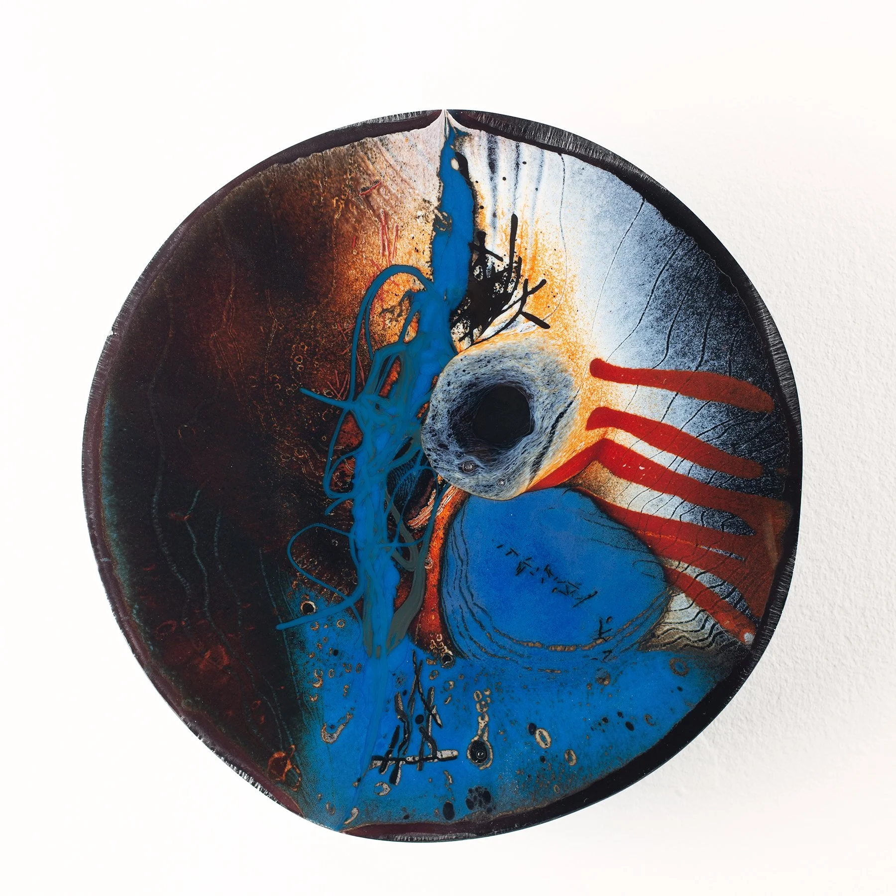 Abstract mixed-media art piece featuring black, blue, white, red, and orange splashes and streaks, with a prominent black hole orcircle in the center.