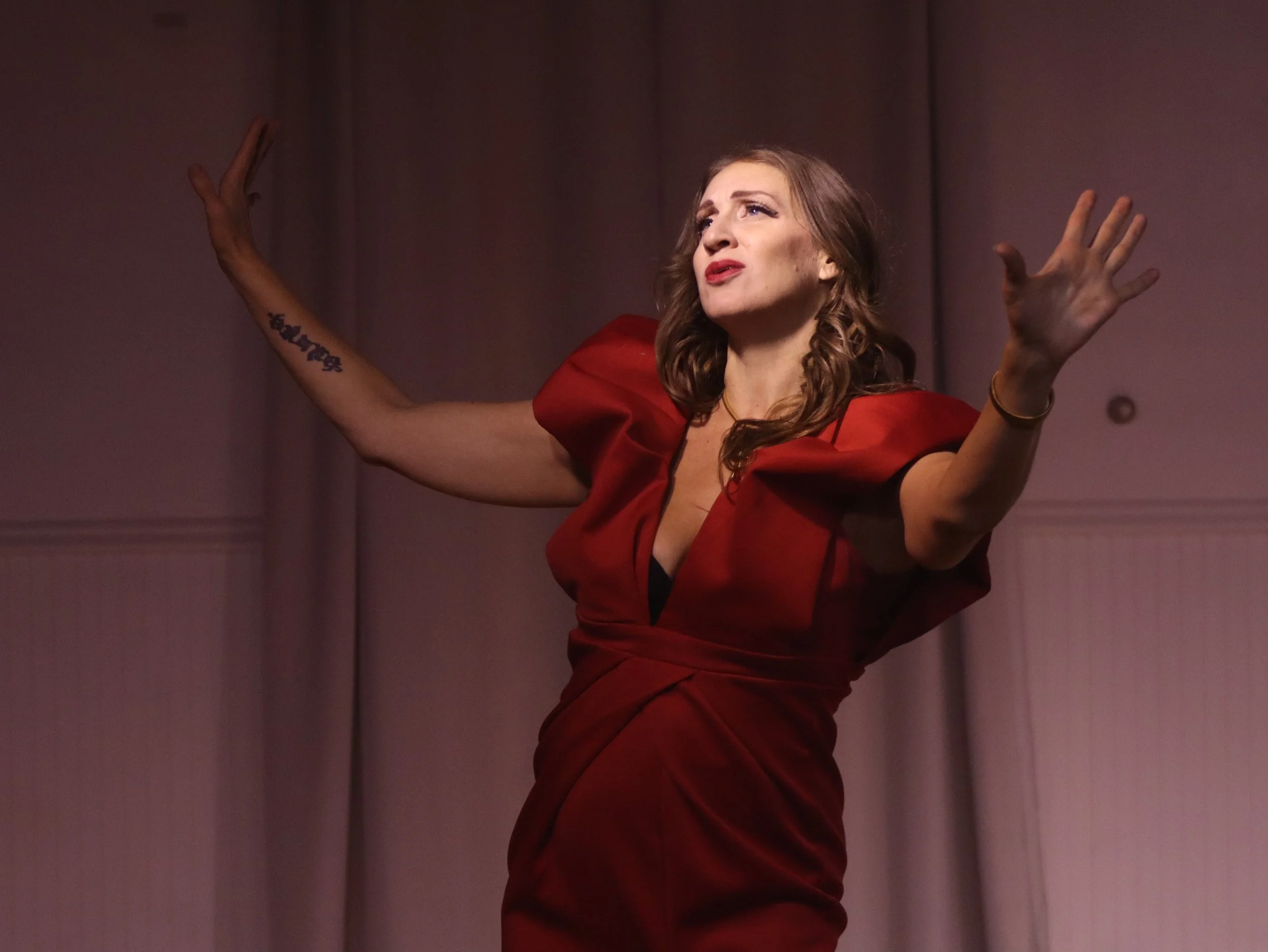 An actor in a red dress in Robbie, an immersive theater show in Eureka Springs Arkansas, near Fayetteville, Bentonville, Rogers, and Springdale.