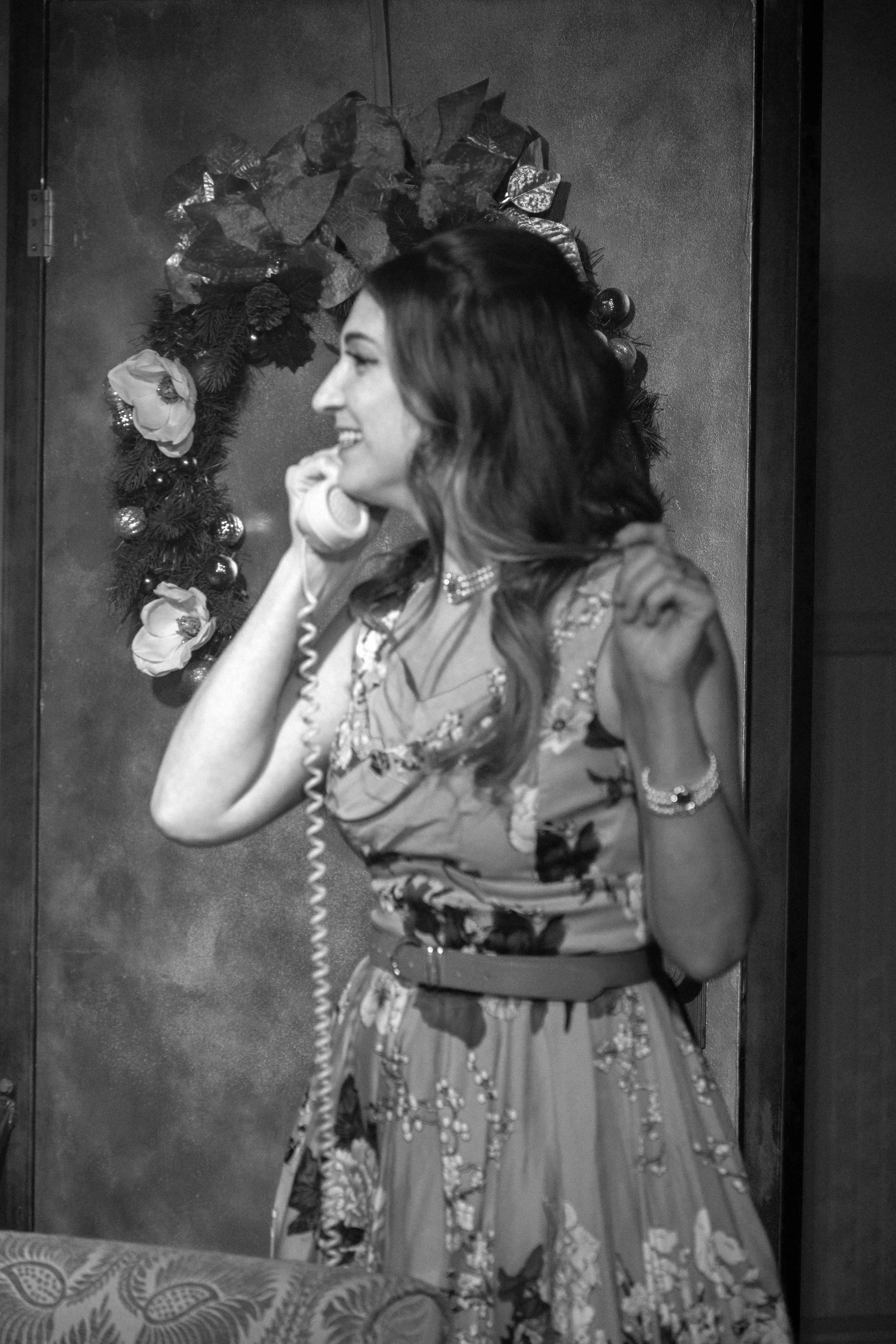 Actor speaks eagerly into a corded phone in Halloween With the Rosses, an immersive theater show in Eureka Spring Arkansas near Bentonville, Fayetteville, Rogers, and Springdale.