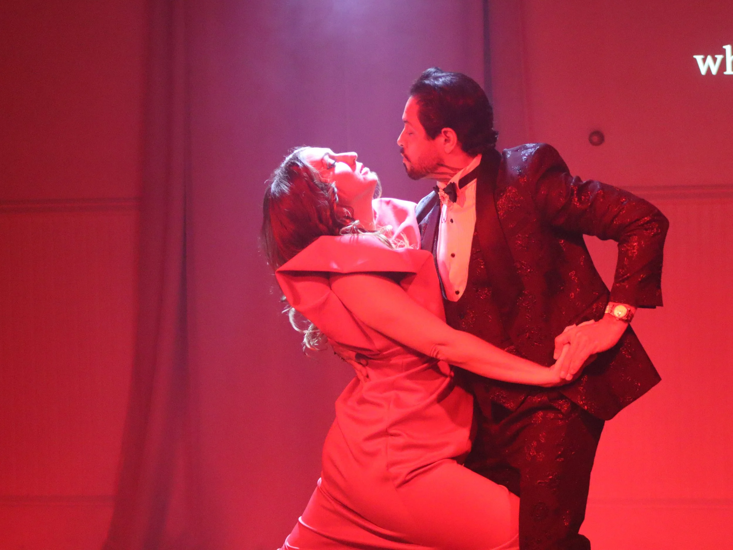 Actors Raymond and Emily dance a passionate tango under red stage lighting in the noir production of ROBBIE! at the Melonligh Theater in Eureka Springs, serving Northwest Arkansas.