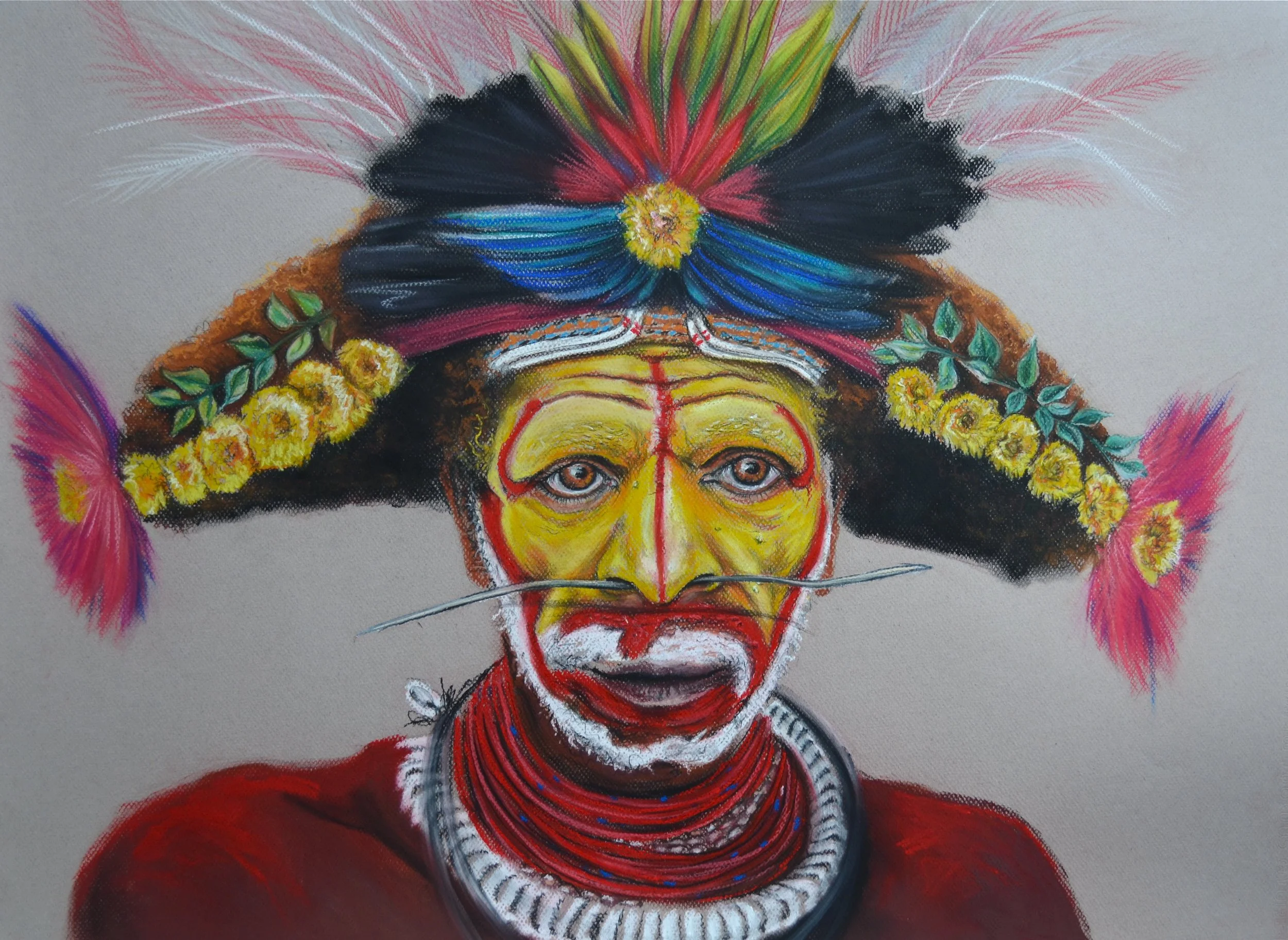 Portrait of a person in traditional tribal makeup and attire, wearing a large, colorful feathered headdress decorated with yellow flowers and feathers, with face painted in yellow and red patterns, and wearing multiple red necklaces.