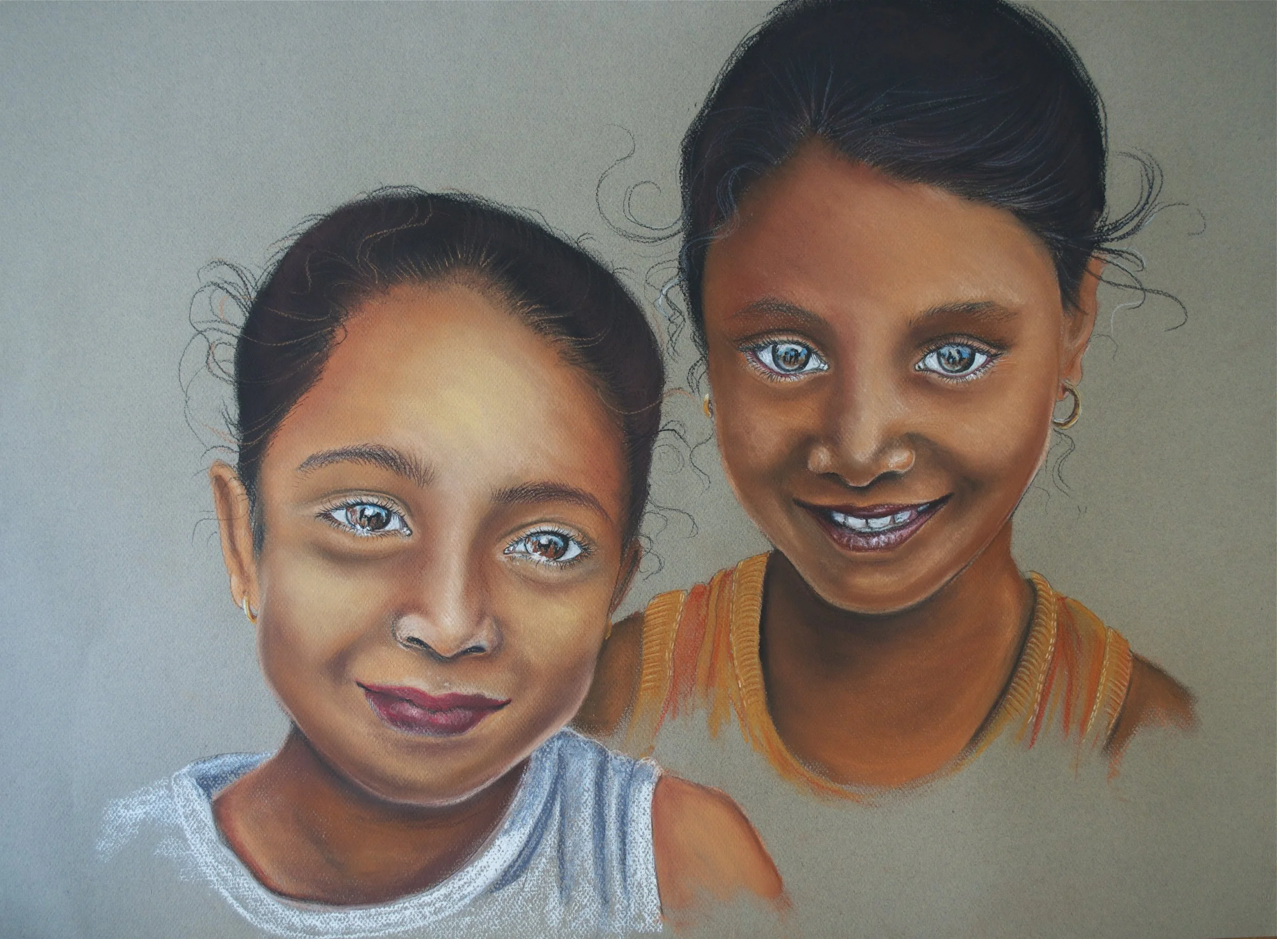 Colorful portrait of two smiling young girls with bright blue eyes, one wearing a gray shirt and the other wearing an orange top, against a plain background.