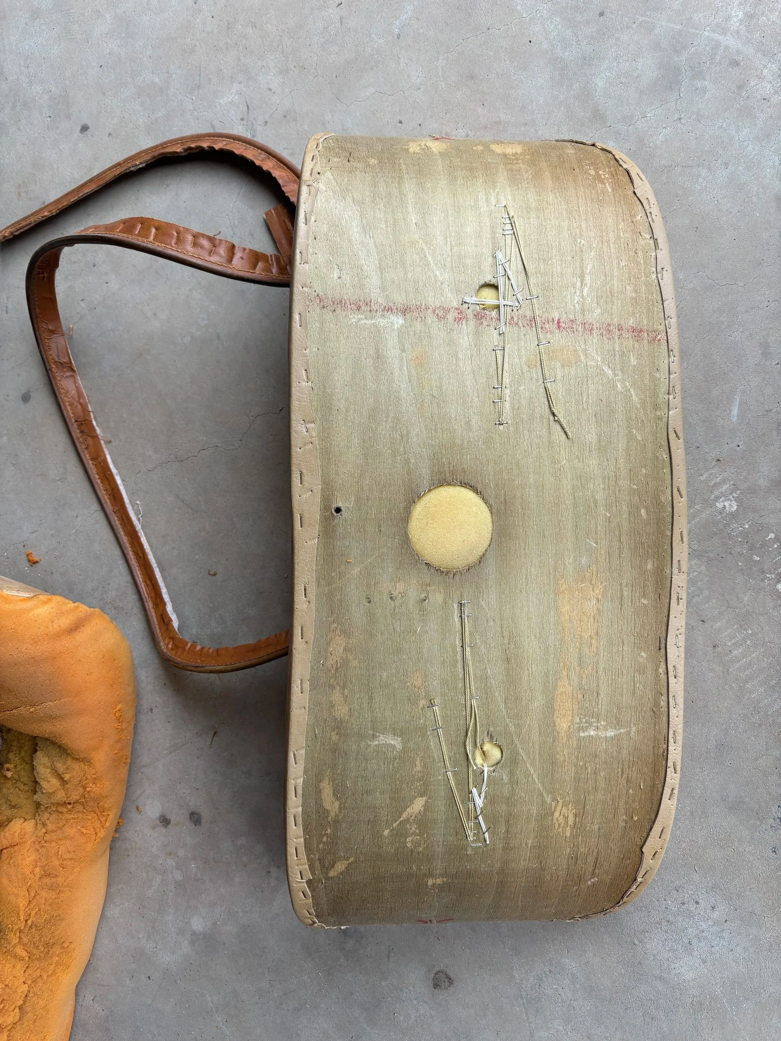 pieces of a deconstructed old chair on a cement garage floor