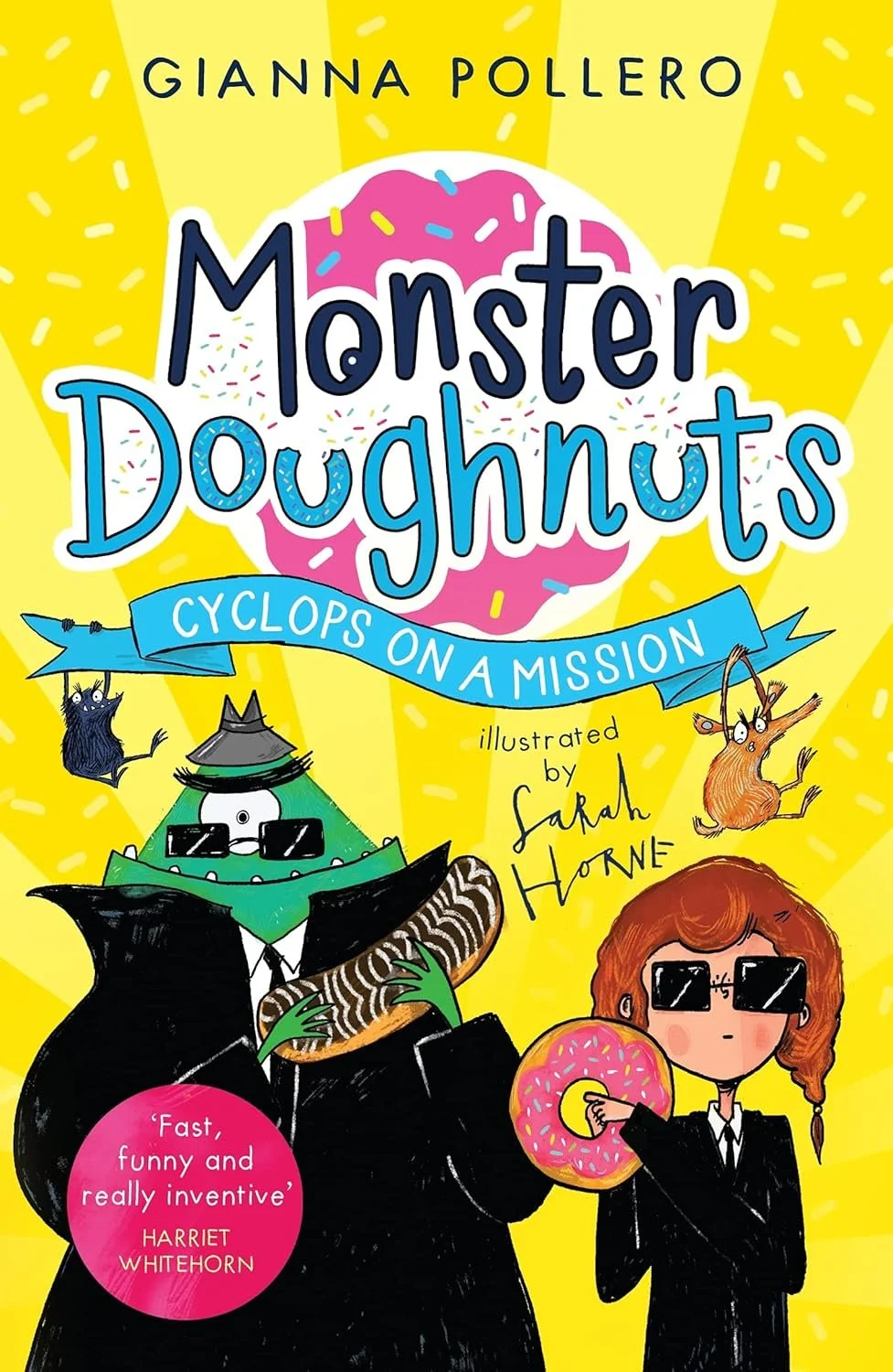 The cover of the children's book titled 'Monster Doughnuts: Cyclops on a Mission' by Sarah Horne, featuring colorful cartoon illustrations of a cyclops in a suit holding a doughnut, a girl with sunglasses also holding a doughnut, a small mouse, a sma