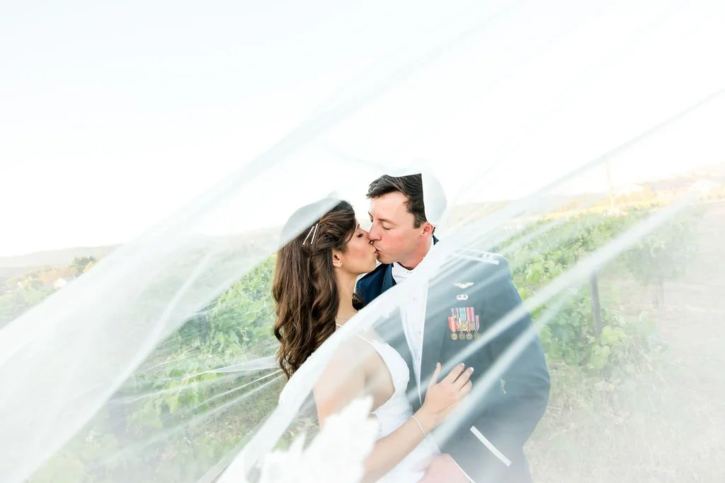 couple kissing through veil blowing in wind
