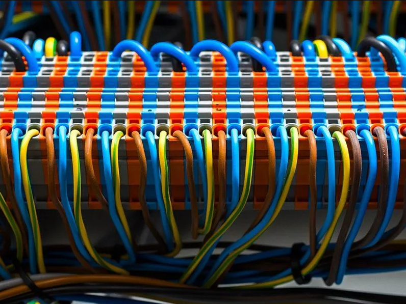 Close-up of a neatly organized array of multicolored Ethernet cables connected to a networking patch panel.