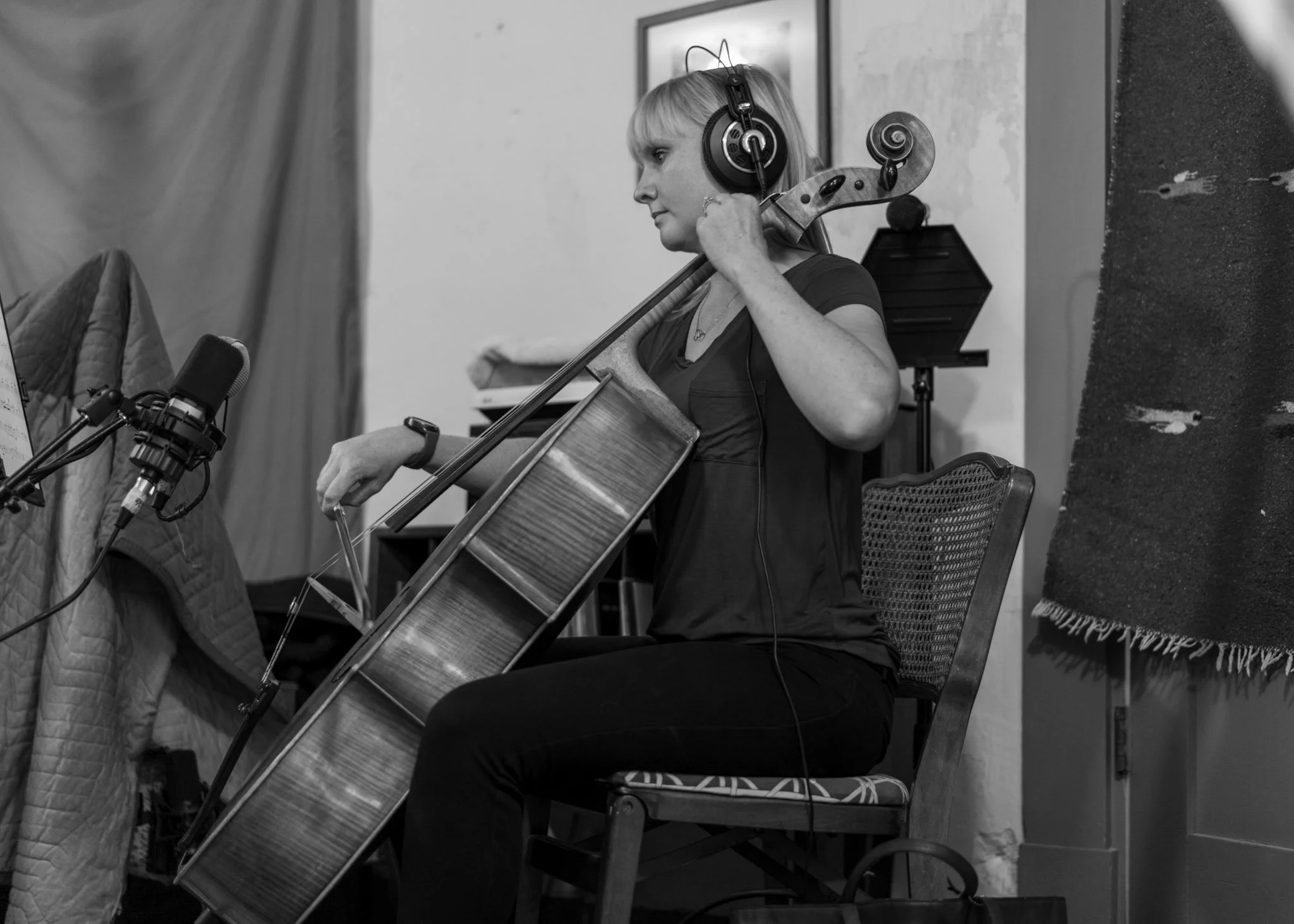 A cellist wearing headphones and playing cello during the Esteban recording session.