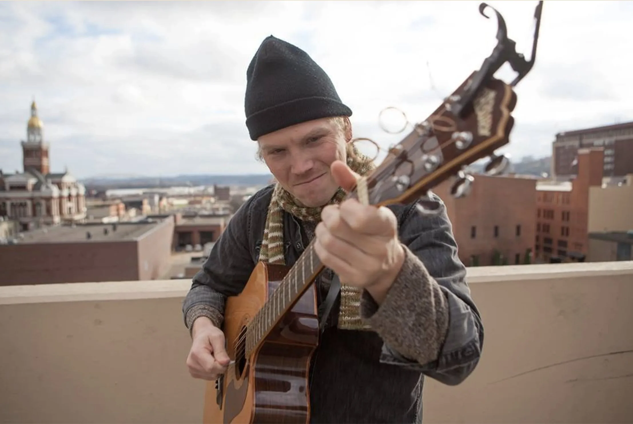 River Breitbach playing guitar on a rooftop outdoors