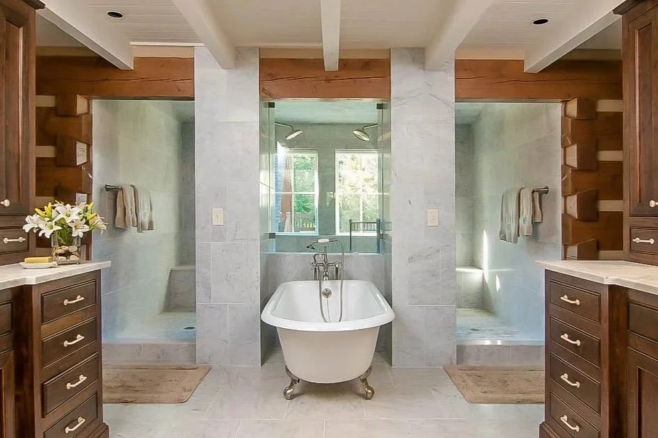 A luxurious bathroom with a vintage clawfoot bathtub centered between two glass shower enclosures, wooden cabinets on either side, and a window with natural light.