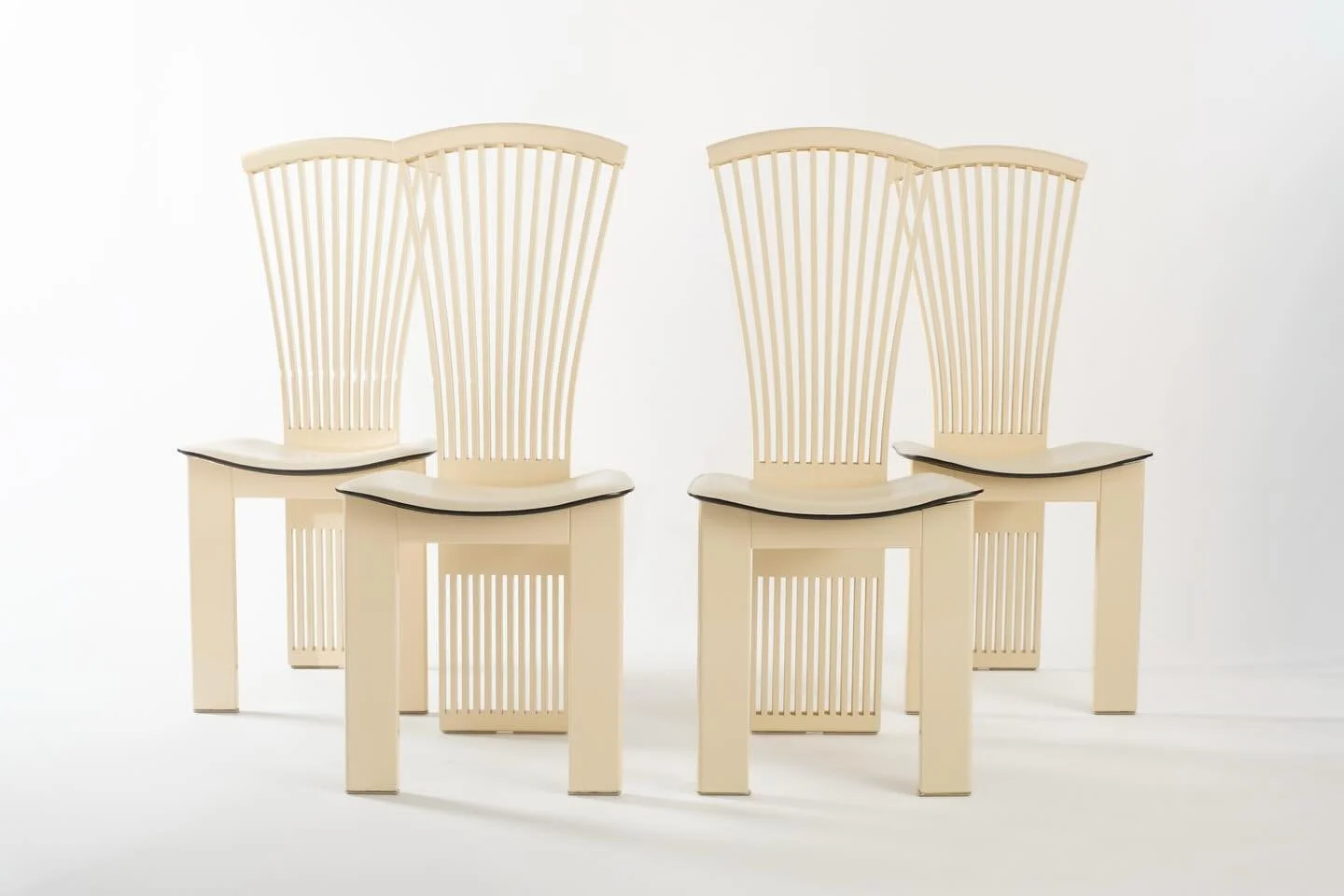 Four Italian dining chairs by Pietro Costantini, imported by Ello, circa 1970s/1980s. The curved seats are generous and comfortable, still in their original white leather upholstery. Yes, they lean into that bold 80s energy, but these chairs have so 