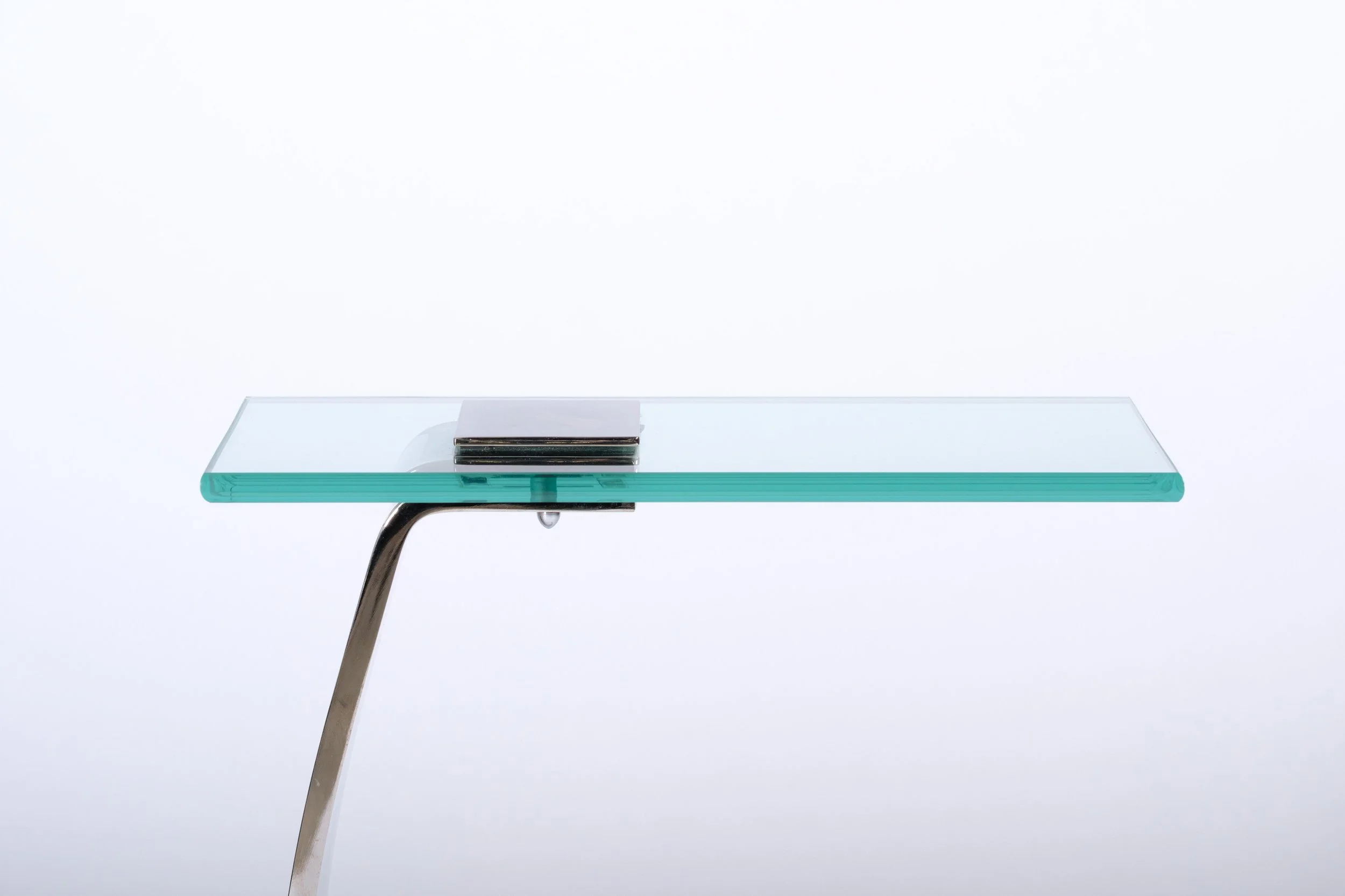 c-shaped side table with glass tabletop and nickel leg and base, close up side and top