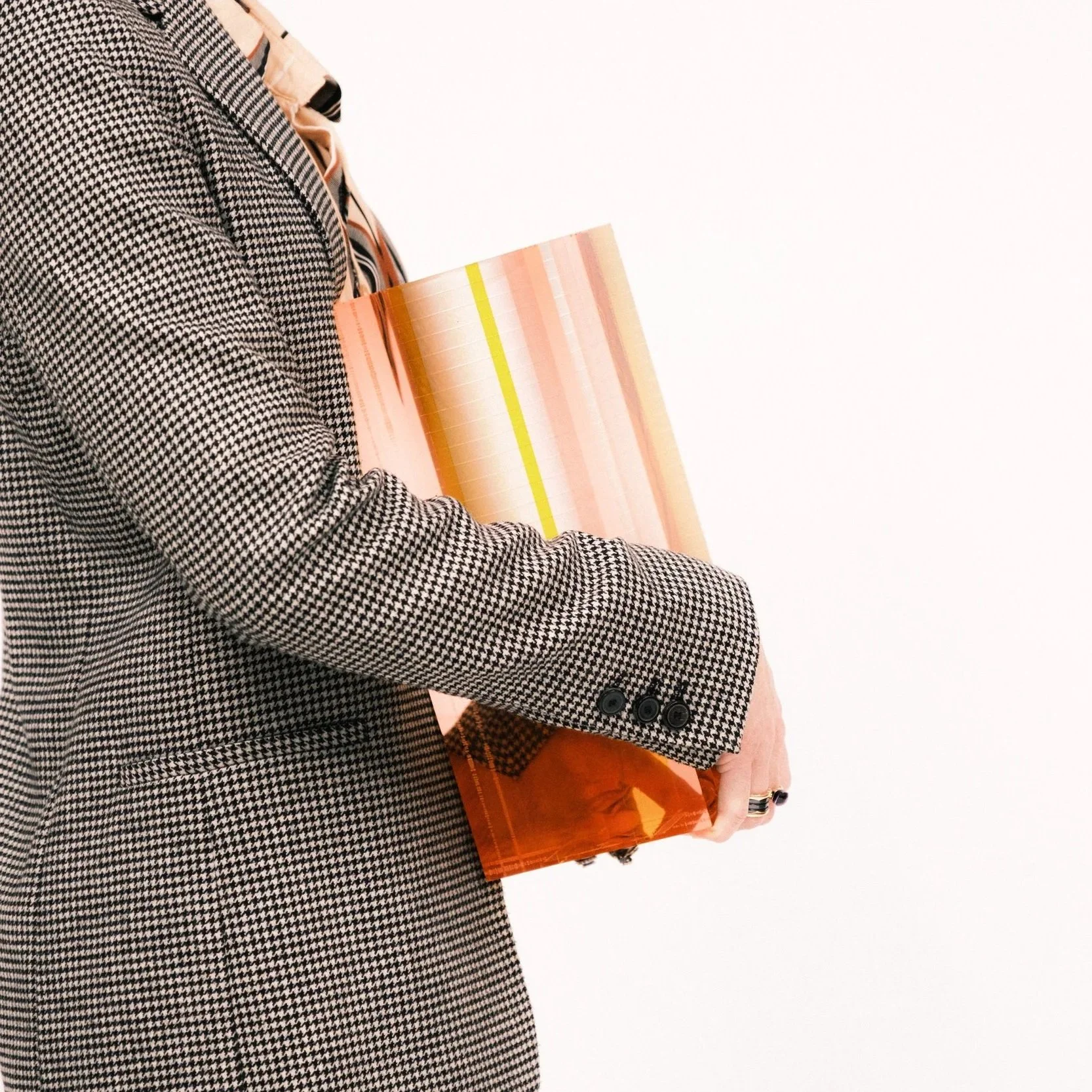 woman holding a square-shaped orange and yellow plexiglass vase against white backdrop