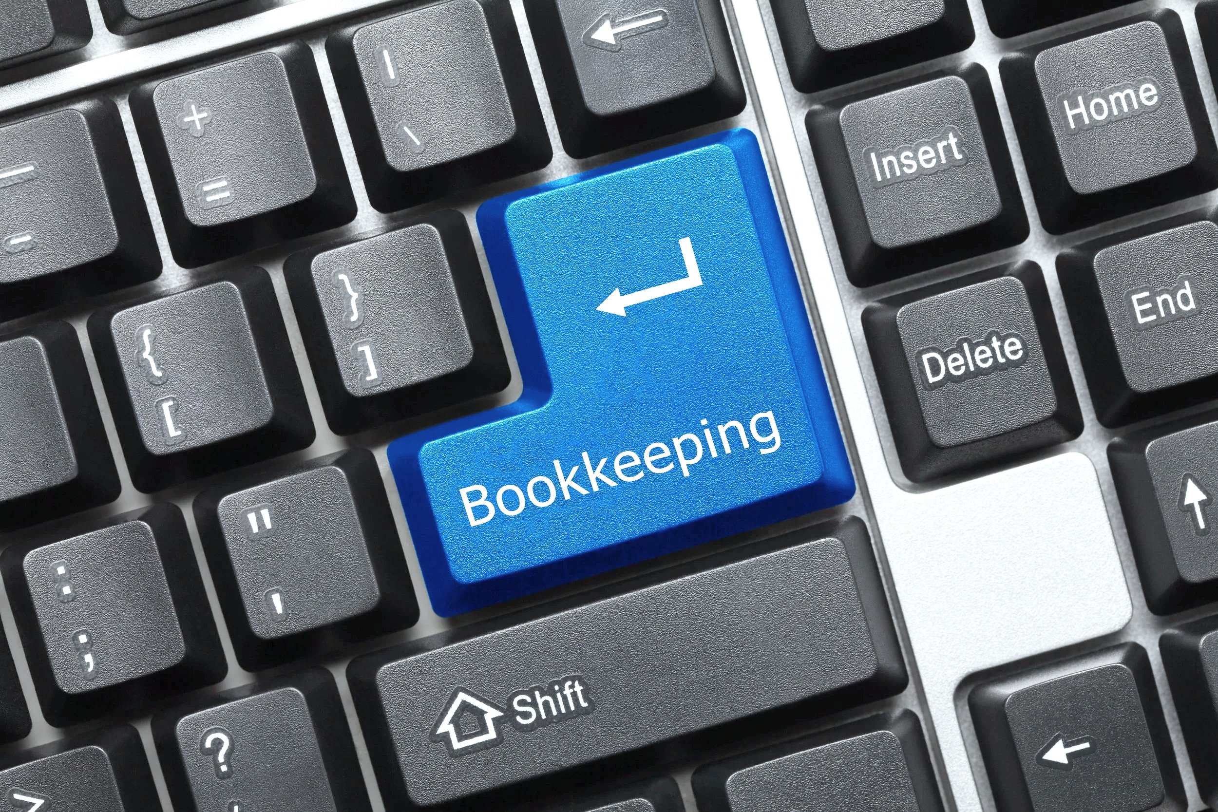 A computer keyboard with a blue key labeled 'Bookkeeping' and an arrow pointing to the left.