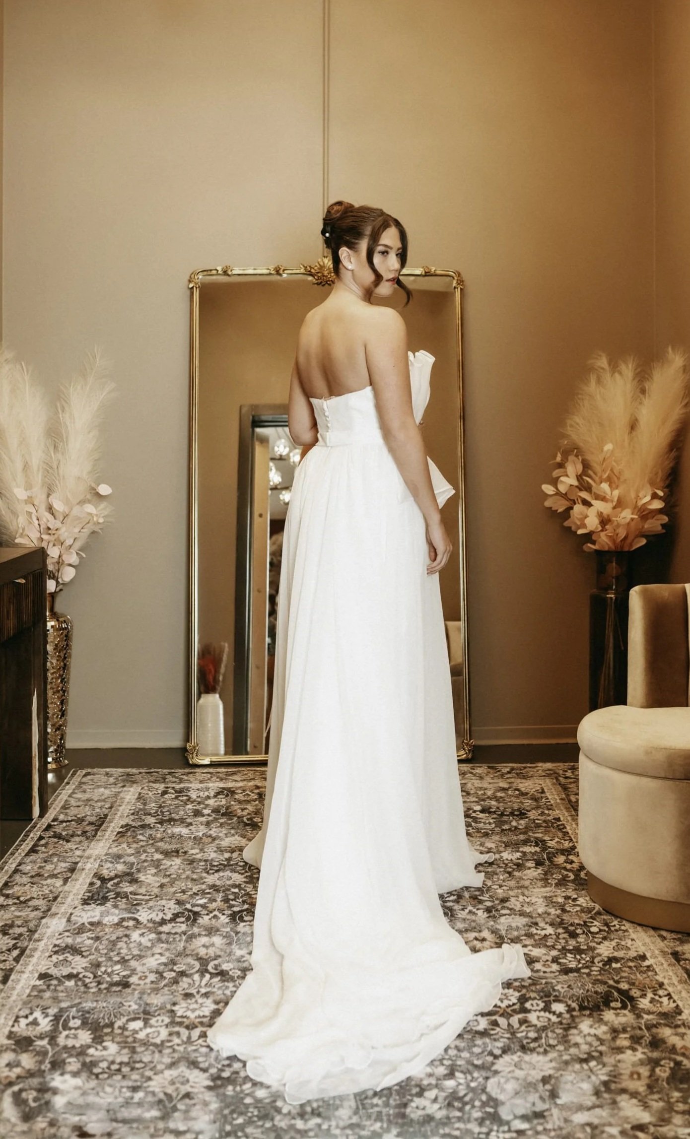 Woman in wedding dress standing in front of full body mirror