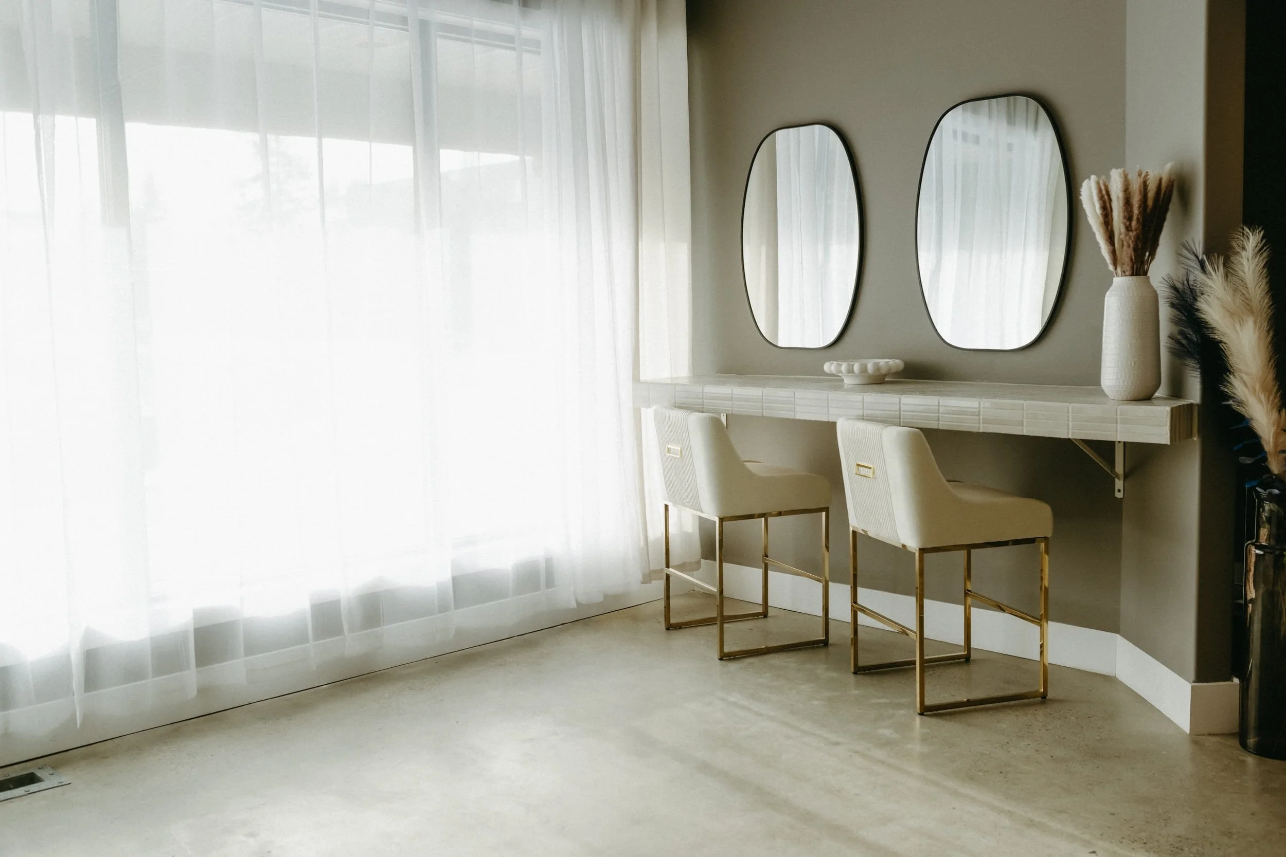 Two chairs at a getting ready space with large mirrors.