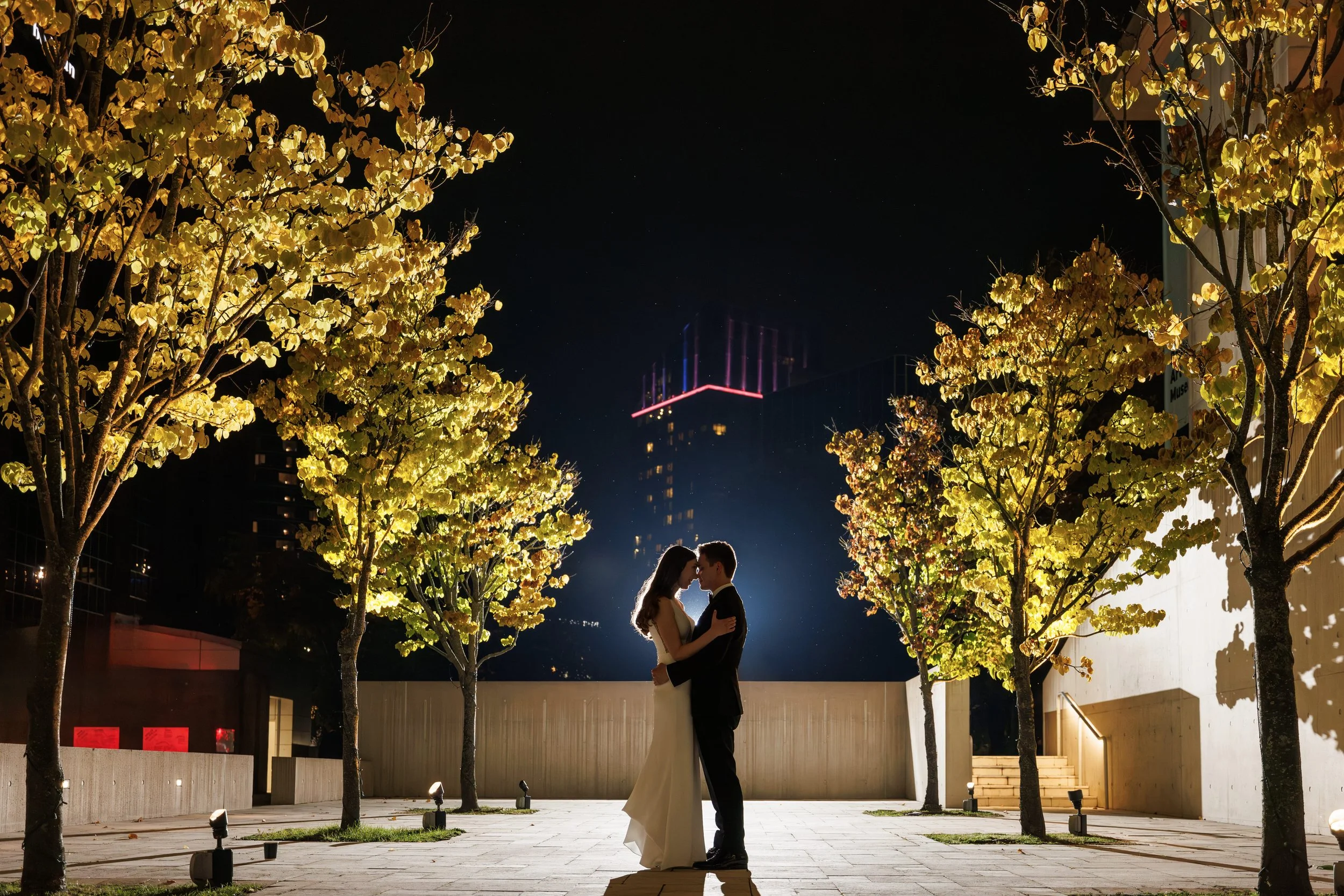 Married Couple. Night time photo shoot with the city scape in background. Wedding Planner & Day of Coordination Services