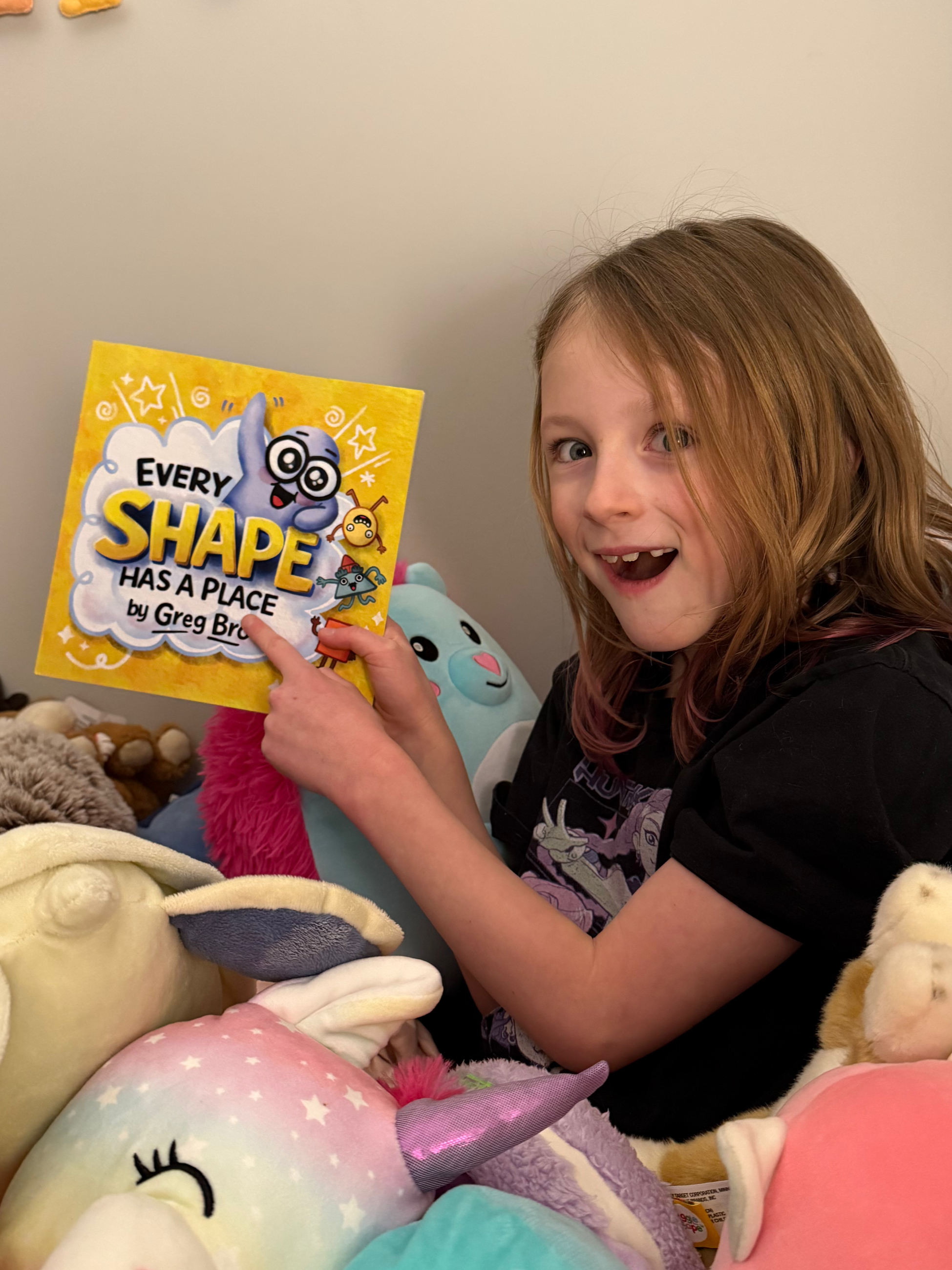 Little girl smiling and reading a book