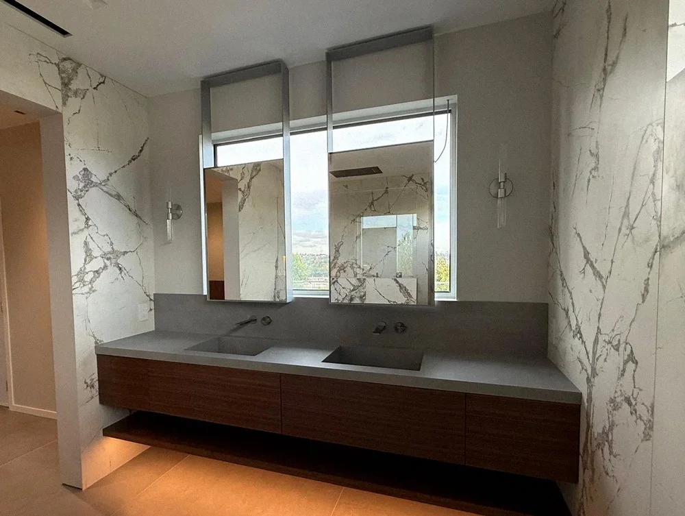 Custom floating bathroom vanity with wood cabinetry and stone wall finish, modern Vancouver millwork project