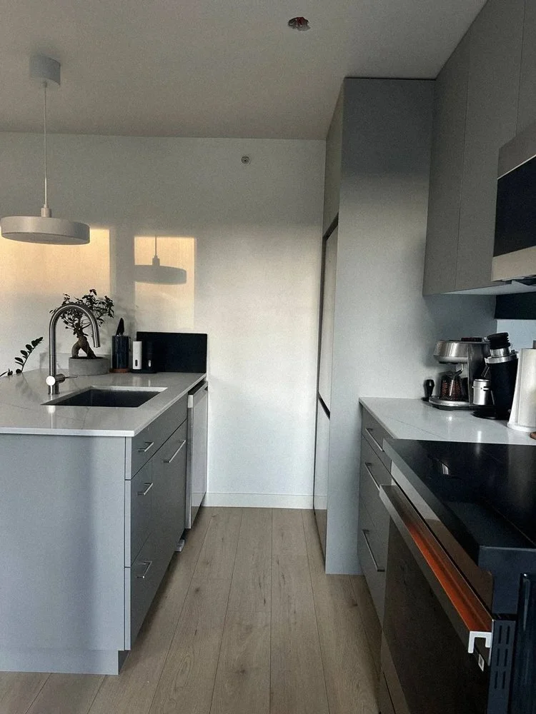 Custom kitchen cabinetry detail with quartz countertop, sink, and integrated storage in Vancouver condo