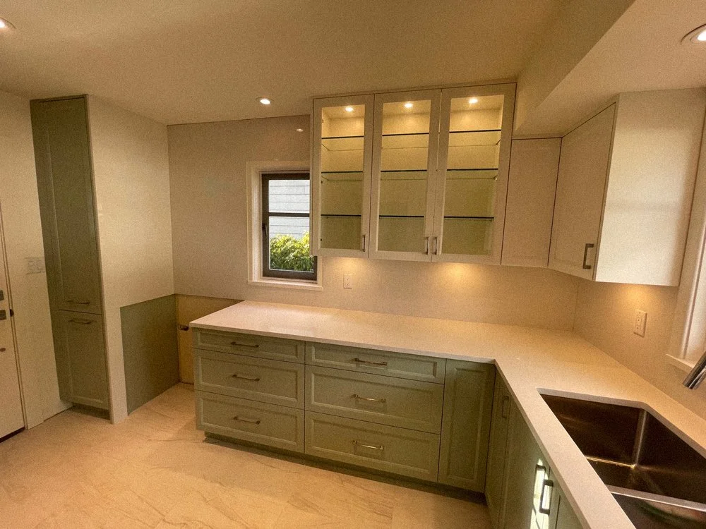 Custom upper kitchen cabinets with glass doors and built-in lighting, North Vancouver millwork project