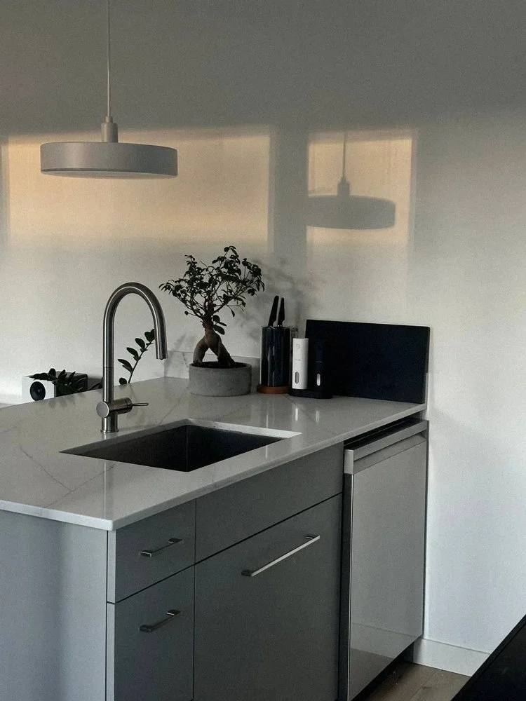 Compact modern kitchen layout with custom cabinets and integrated appliances in Vancouver apartment